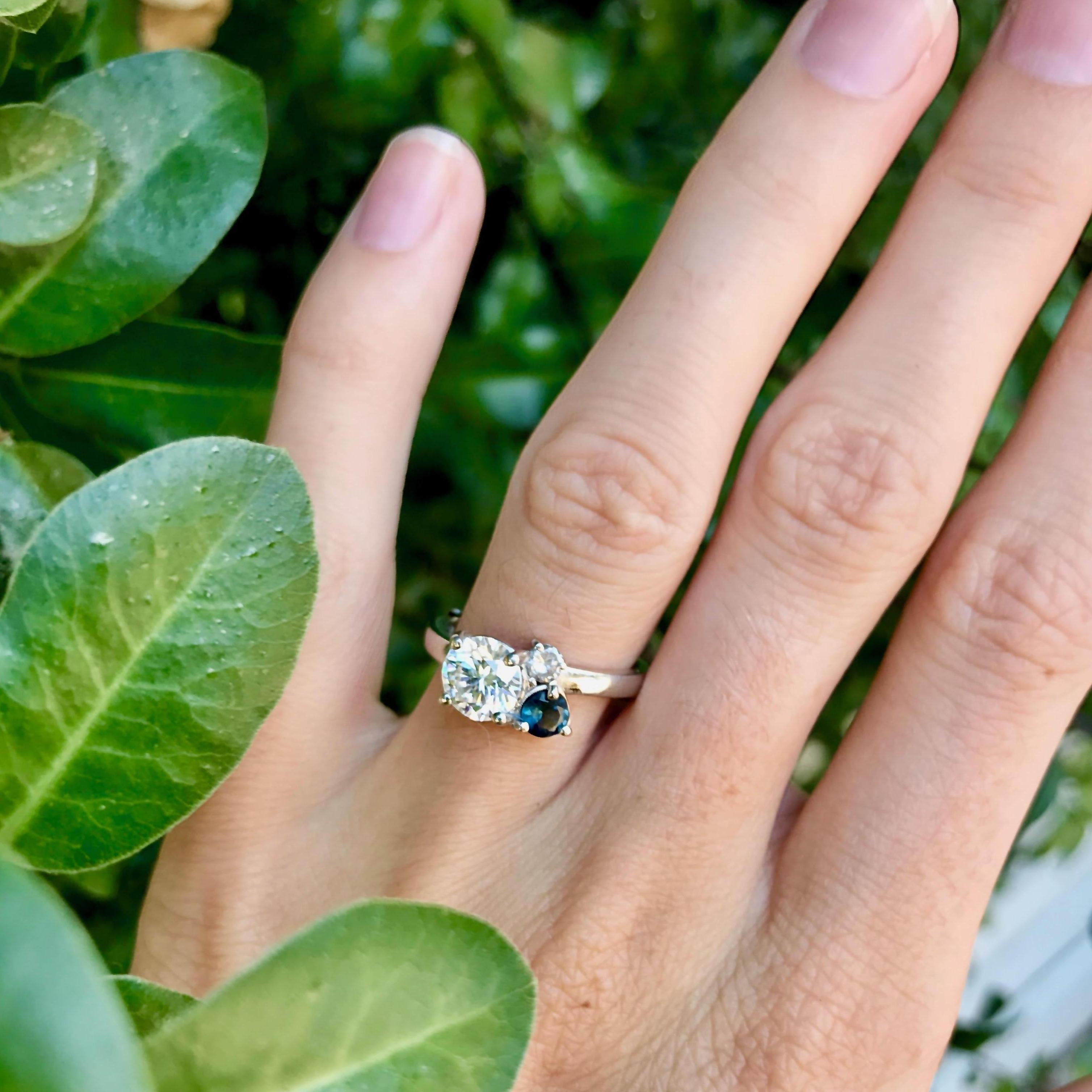 Sarah's engagement ring features a 1.27 Carat Diamond, a smaller Salt and Pepper Diamond, and a Montana Sapphire. Each element represents a part of Sarah and David's eternal relationship with God.