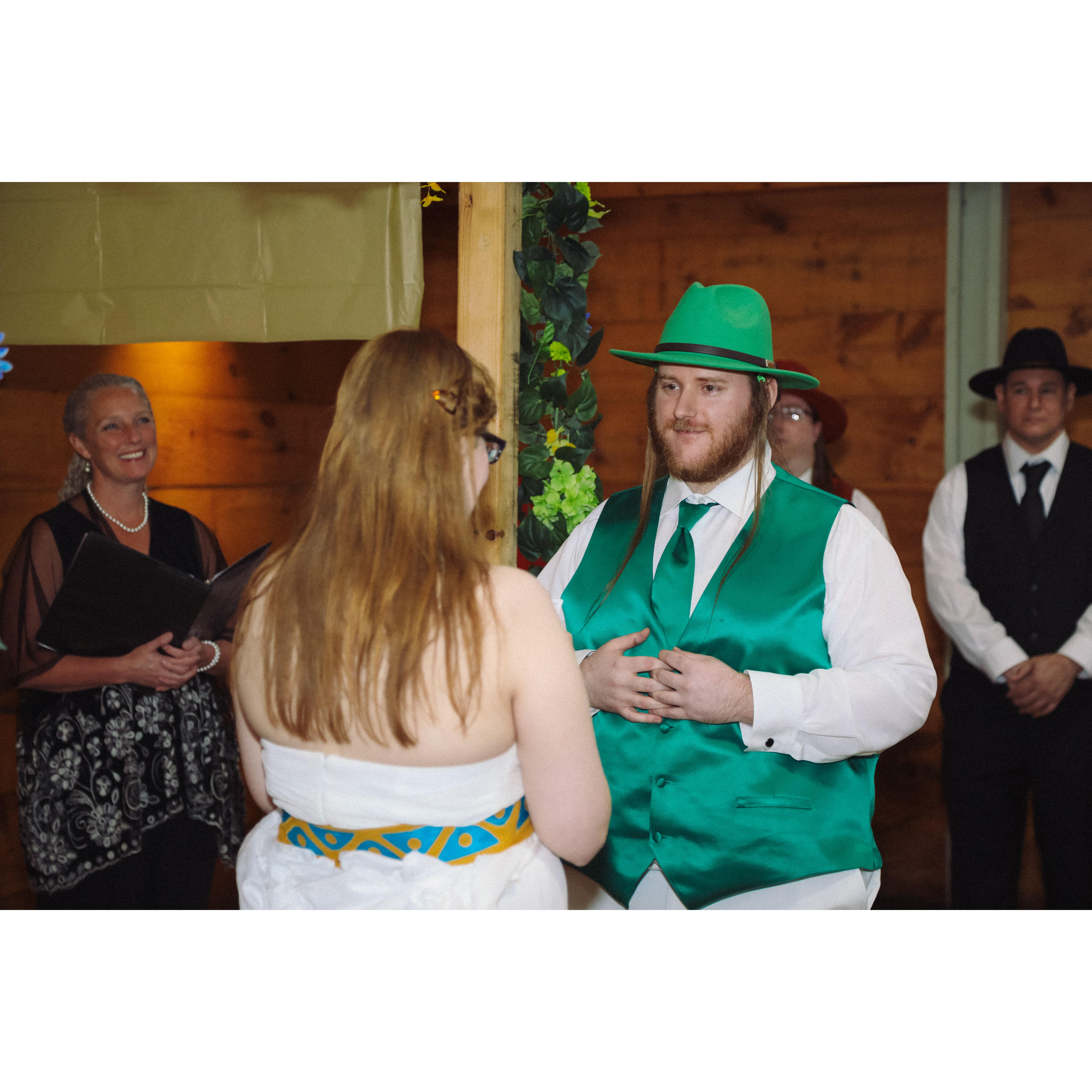 during the ceremony, Sara and Herb under the arch with the officiant vieved from behind Sara