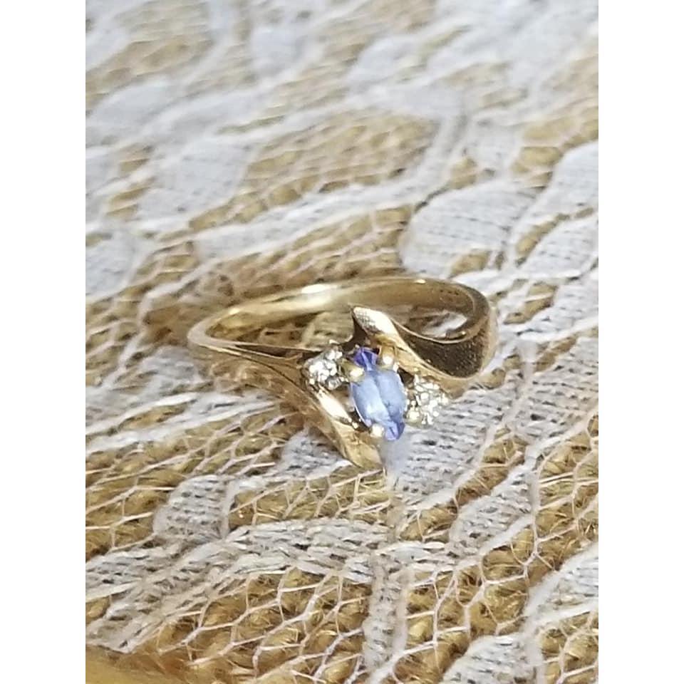 This ring is Tanzanite, set in gold with diamond chips. It came from Cayman Islands and first belonged to Brandons mother.
