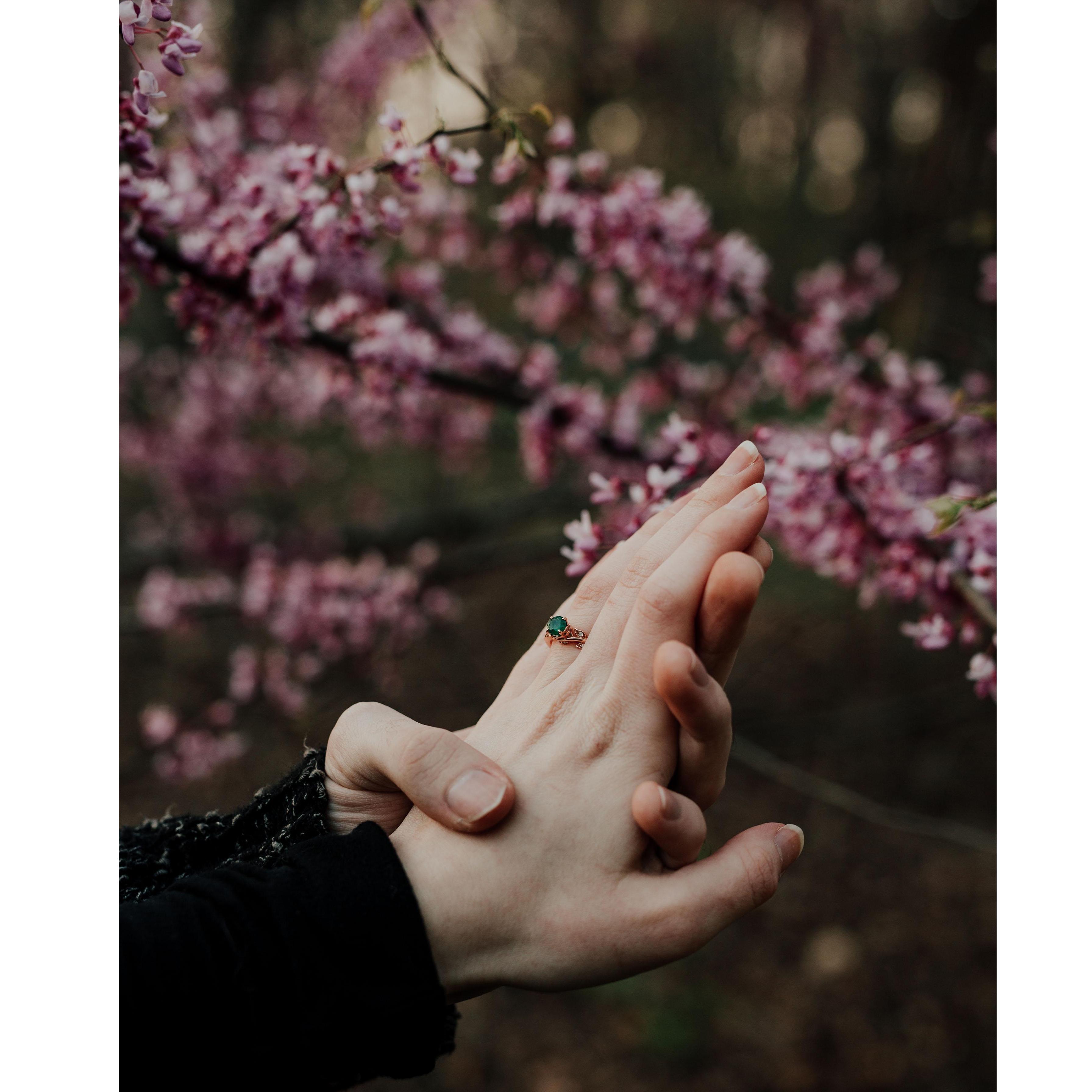 He proposed with a rose gold band that has leaf detailing on the top and wrapping around the emerald stone!