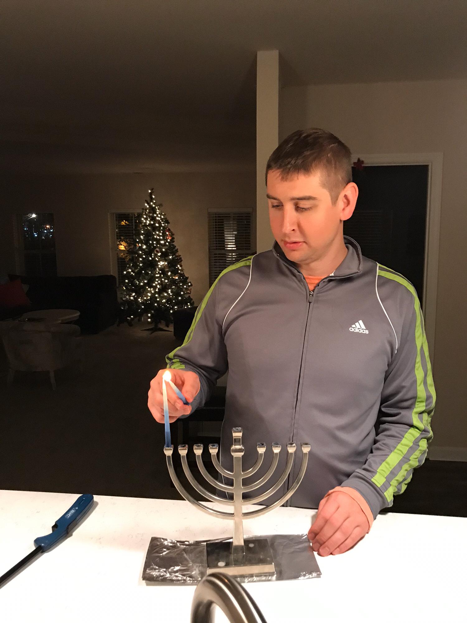 Nate lighting the menorah on the first night of Hanukkah.