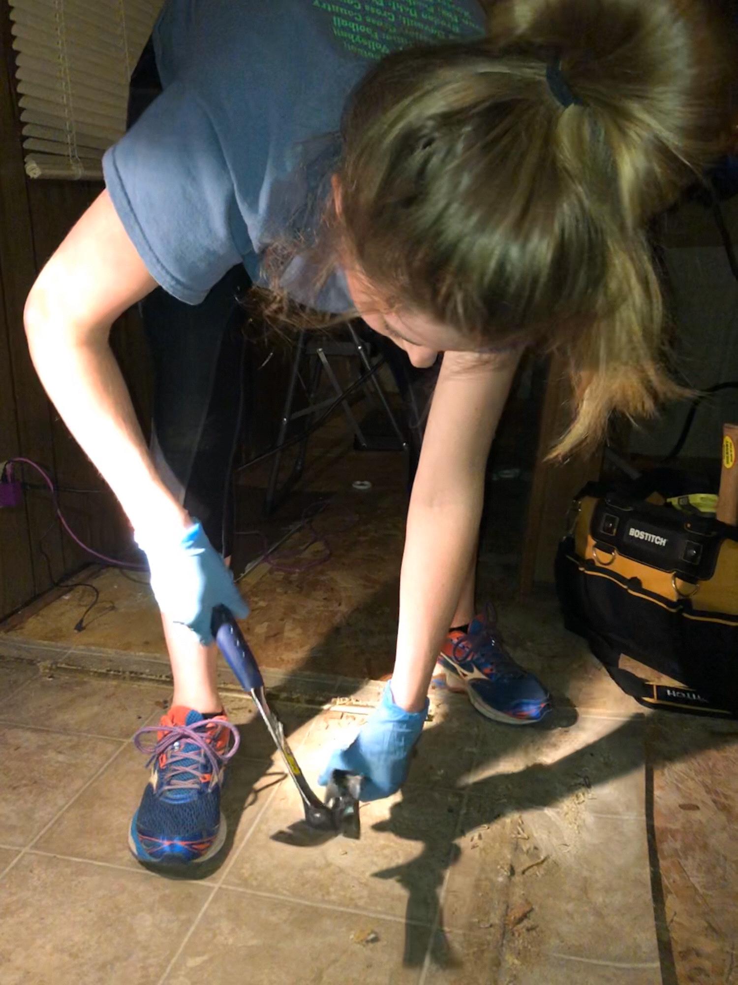Hanna taking up the old flooring our future house.