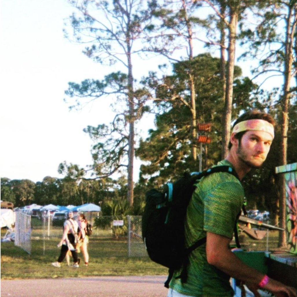 Sean playing the piano in the woods, Okeechobee 2022.