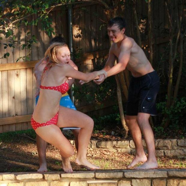 Bobby pushing Jacy into the pool at the pool party she threw the August before their freshman year of high school.
