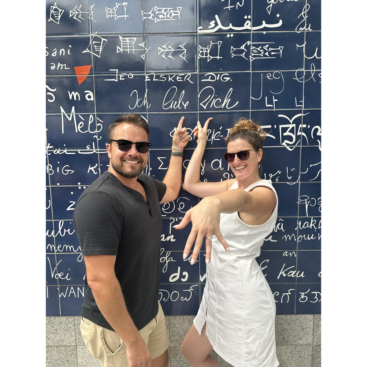 Pointing to "Ich liebe dich" - "I Love You" in German at the Wall of Love in Paris