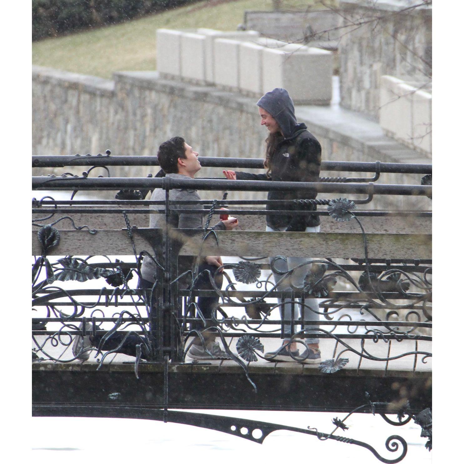 A very happily, shocked Kim that Isaac is on one knee with a ring in his hand.