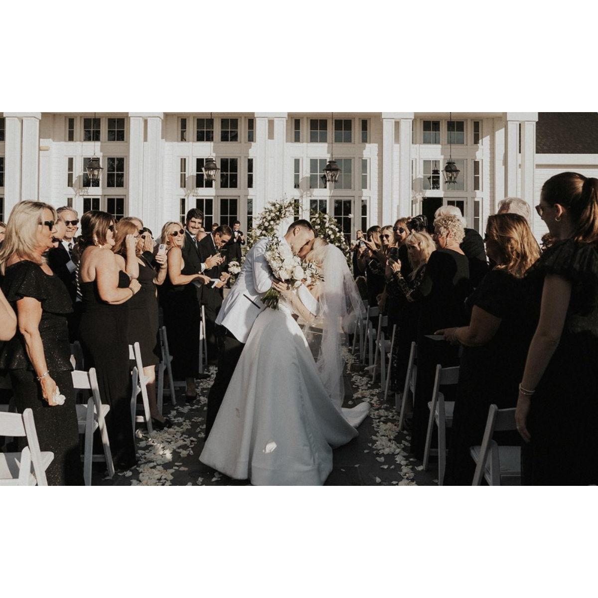 Guests dressed in All Black, Bride + Groom in White.