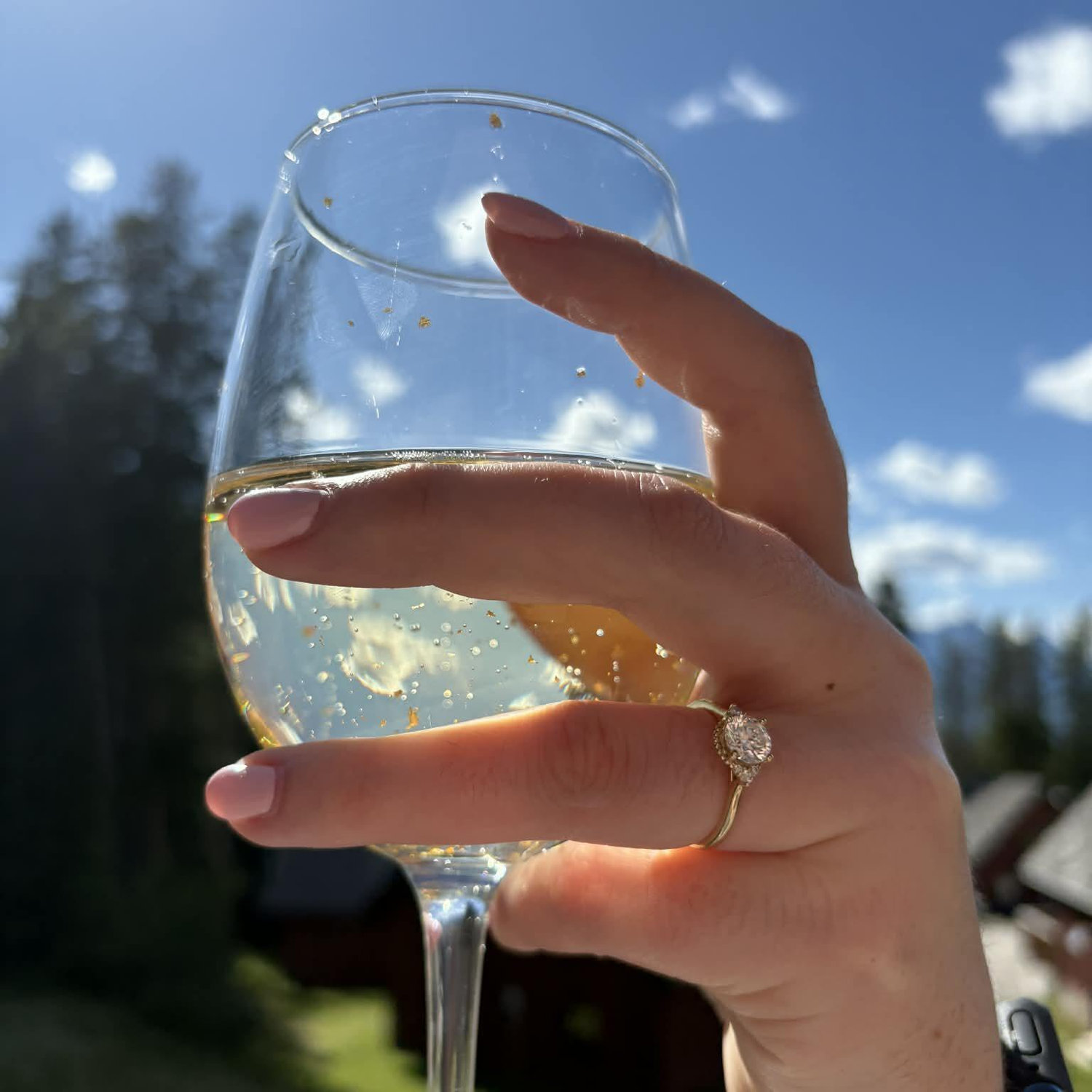 Champagne to celebrate. No ice in the glass because it is on her finger.