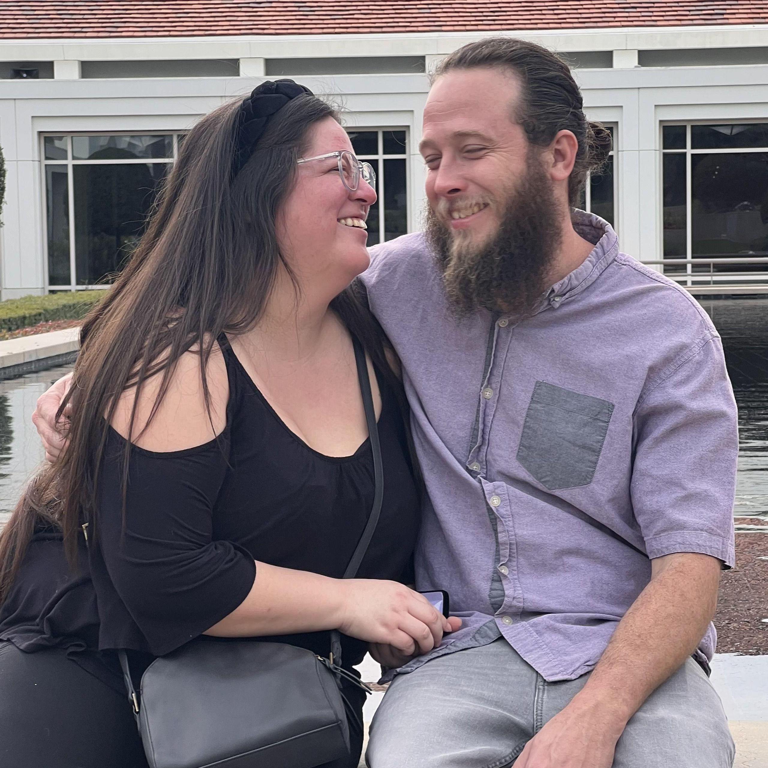 Fiances smiling. Fun fact the groom wore the same top from their first date.