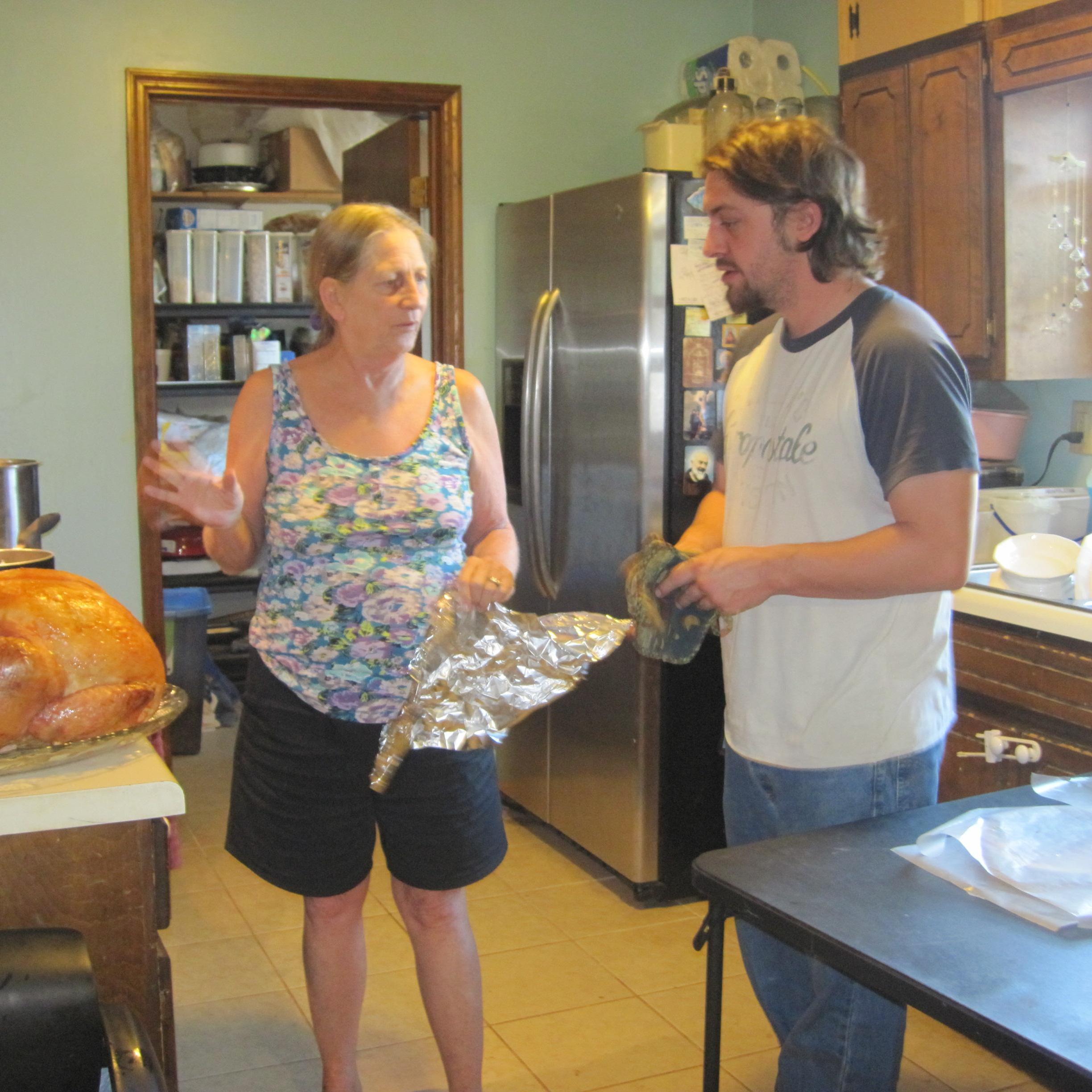 Grandma explaining how to handle the turkey to Brandon.