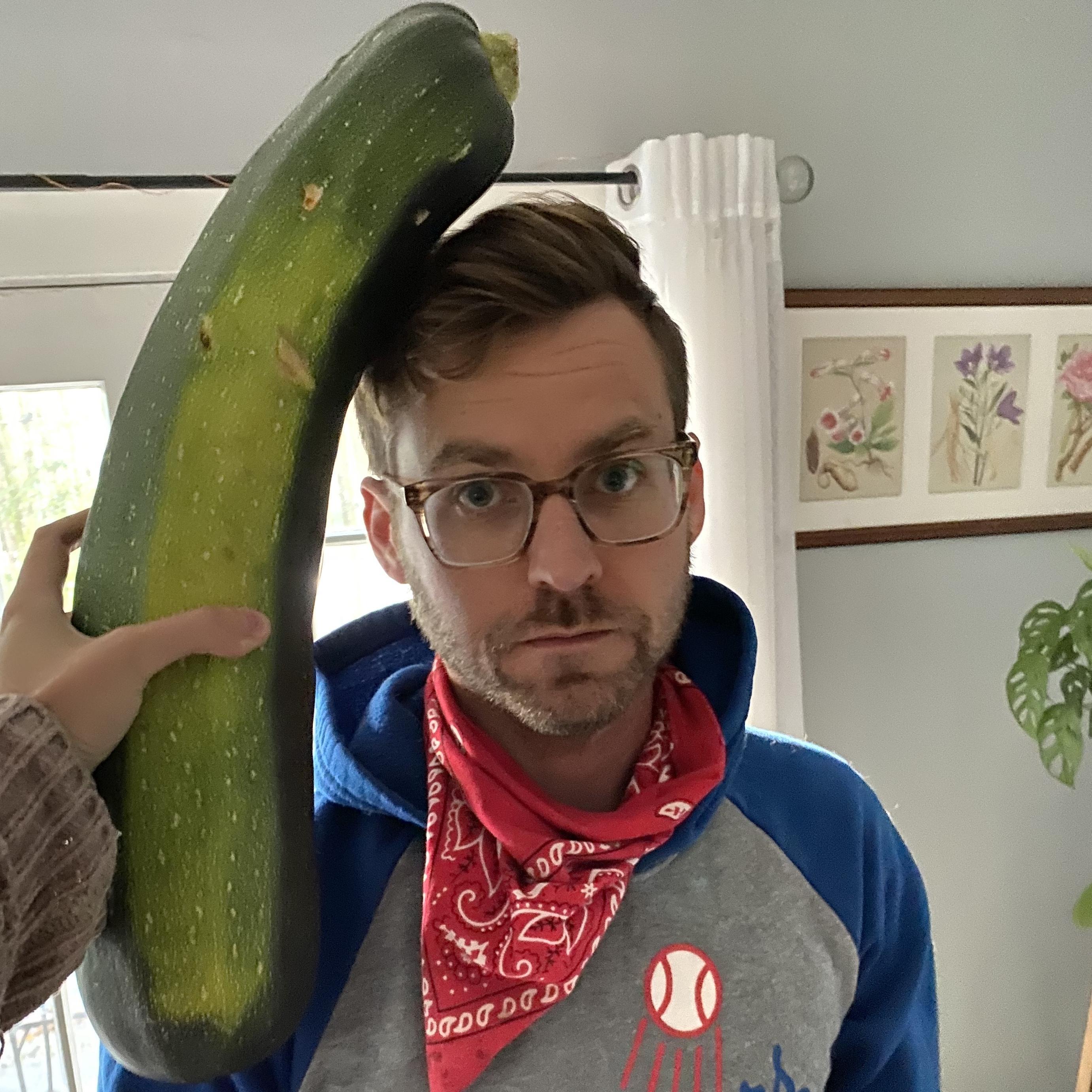 Maggie comparing the size of this zucchini to Ryan's head.