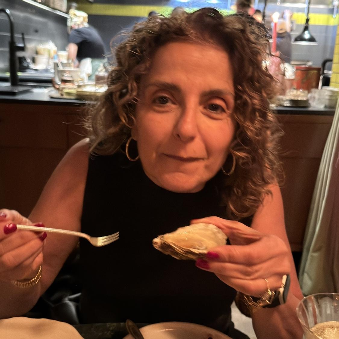 Eating her first oyster-- Yumm!