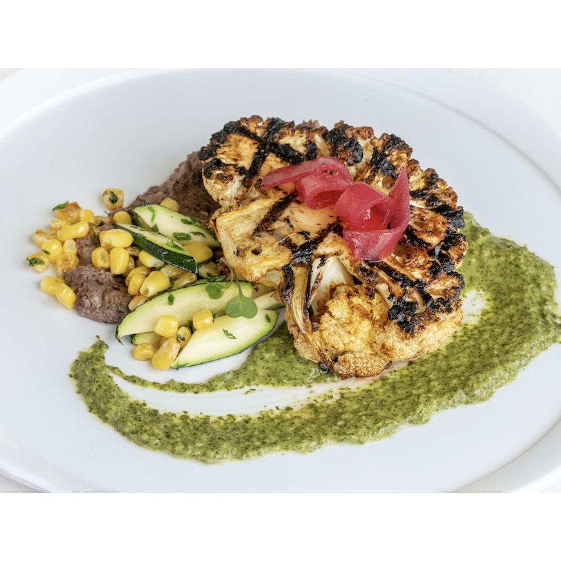 Southwestern Cauliflower Steak  (vegan and gluten free): Spice Rubbed Cauliflower Steak Served with Refried Black Beans, Salsa Verde, and a Corn & Squash Medley. Topped with Pickled Red Onions.