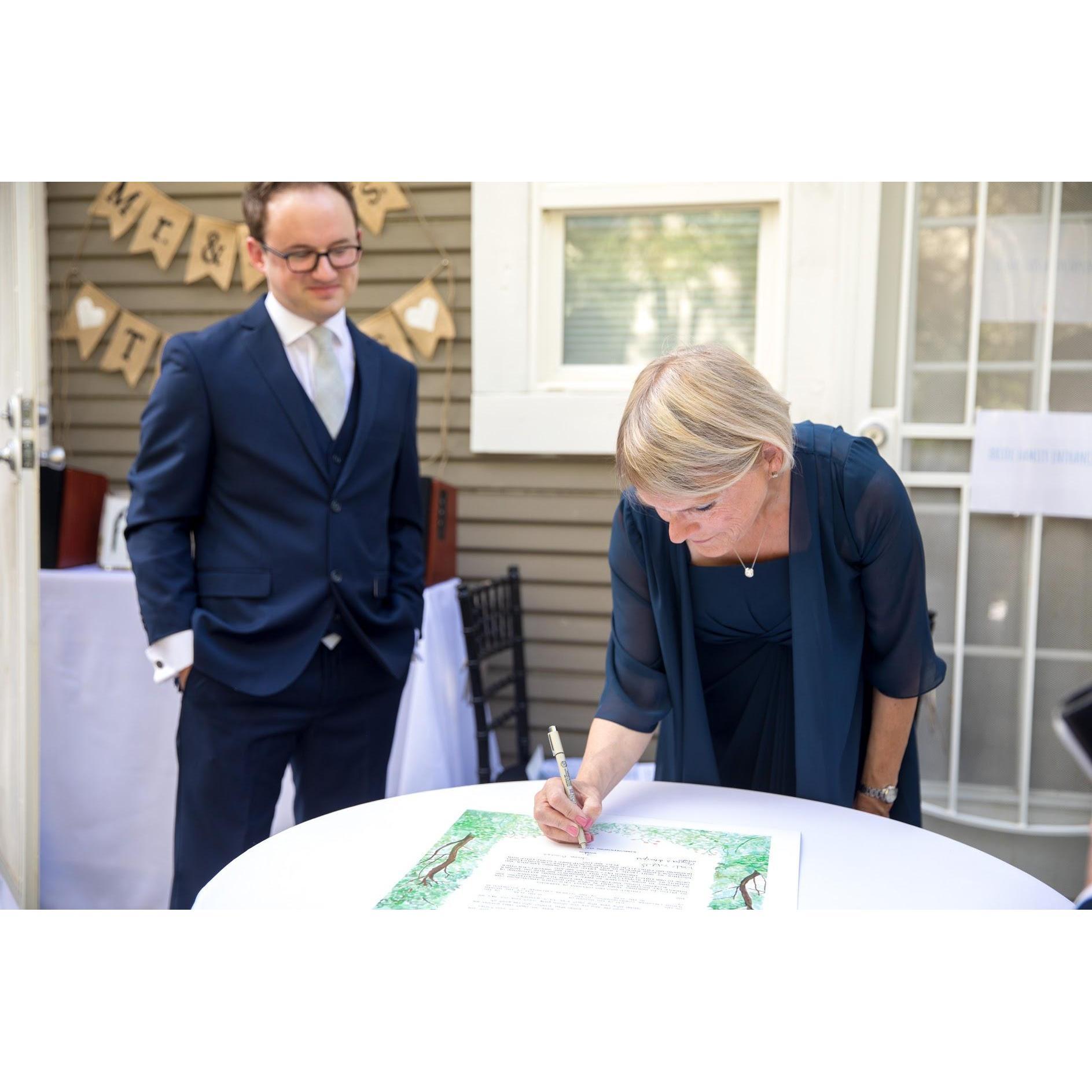 Steve and his mother, Karen, signing the Ketubah