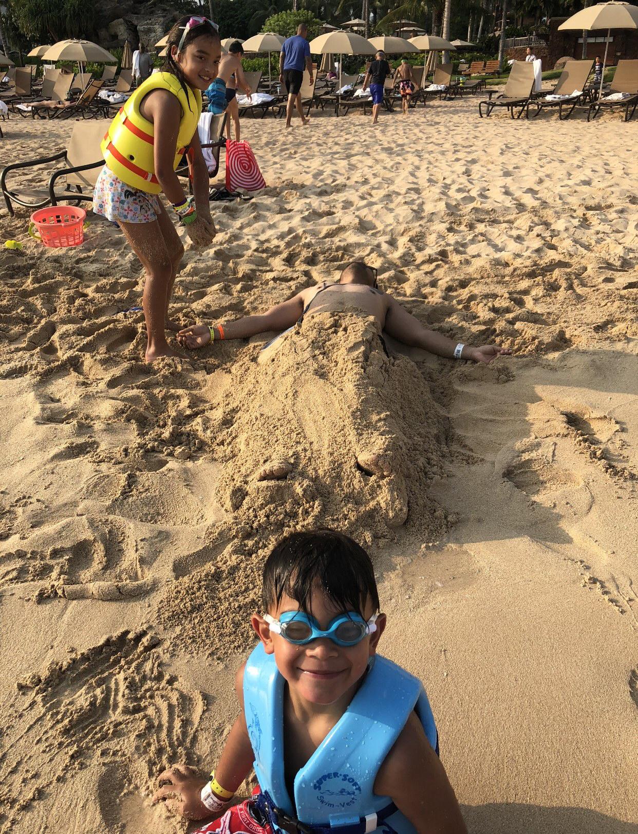 Pic of Keith being buried alive in the sand by Ryan & Michelle at Aulani 😂