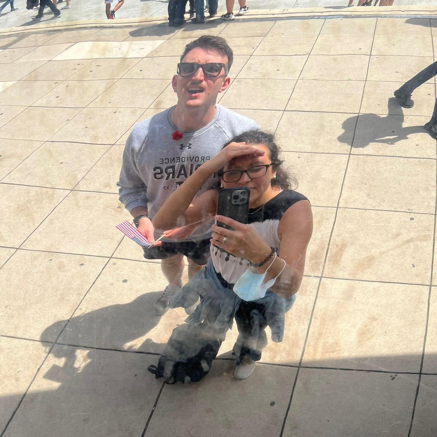 Arriana & Brian noticing that the famous reflective sculpture, Cloud Gate ("the Bean"), in Chicago could use a polish