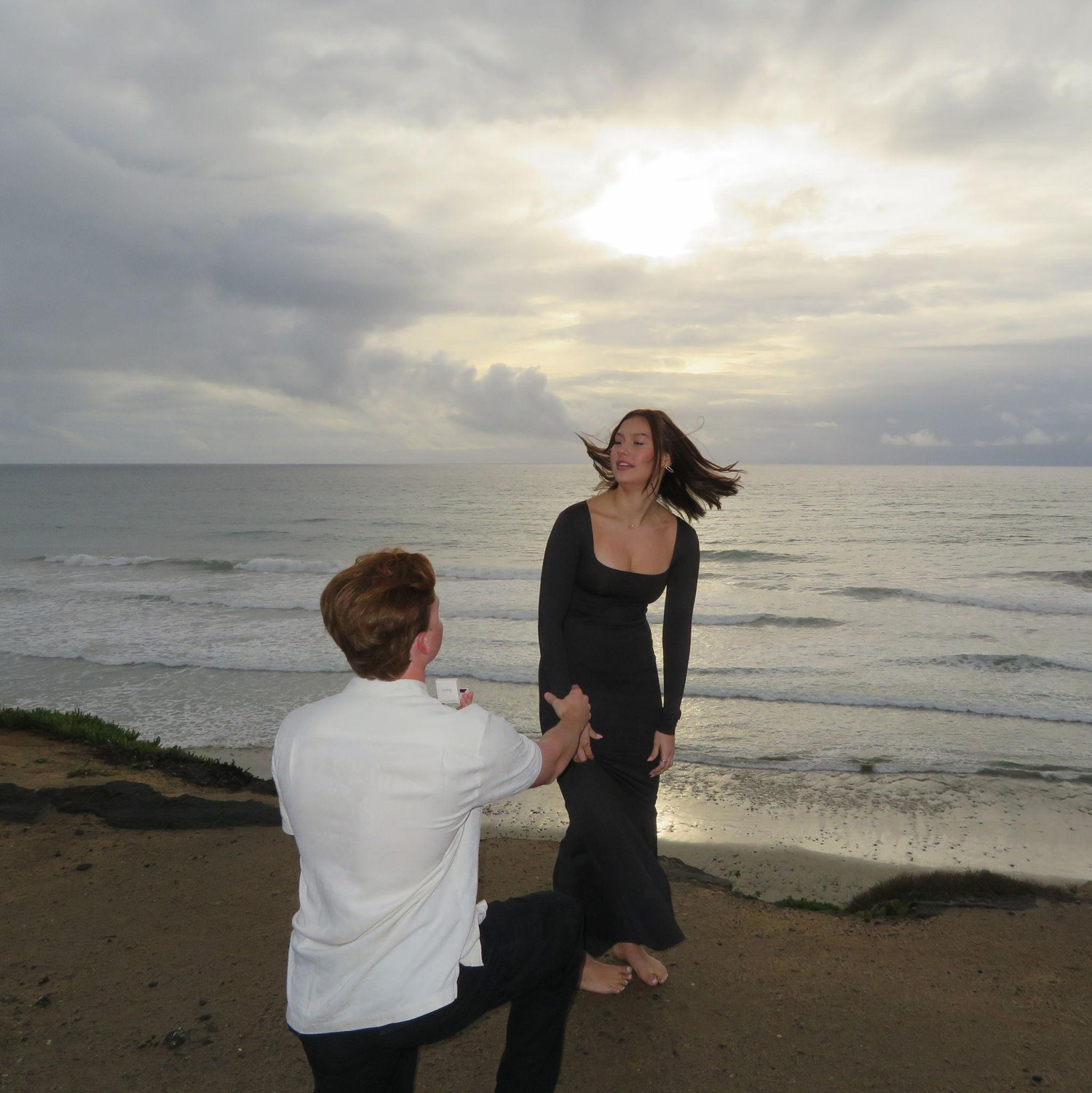 Alexx had us looking out at the ocean for whales, and I was fully convinced. I heard my name and turned to find Connor on one knee. This photo captures the surprise, joy, and unforgettable moment.