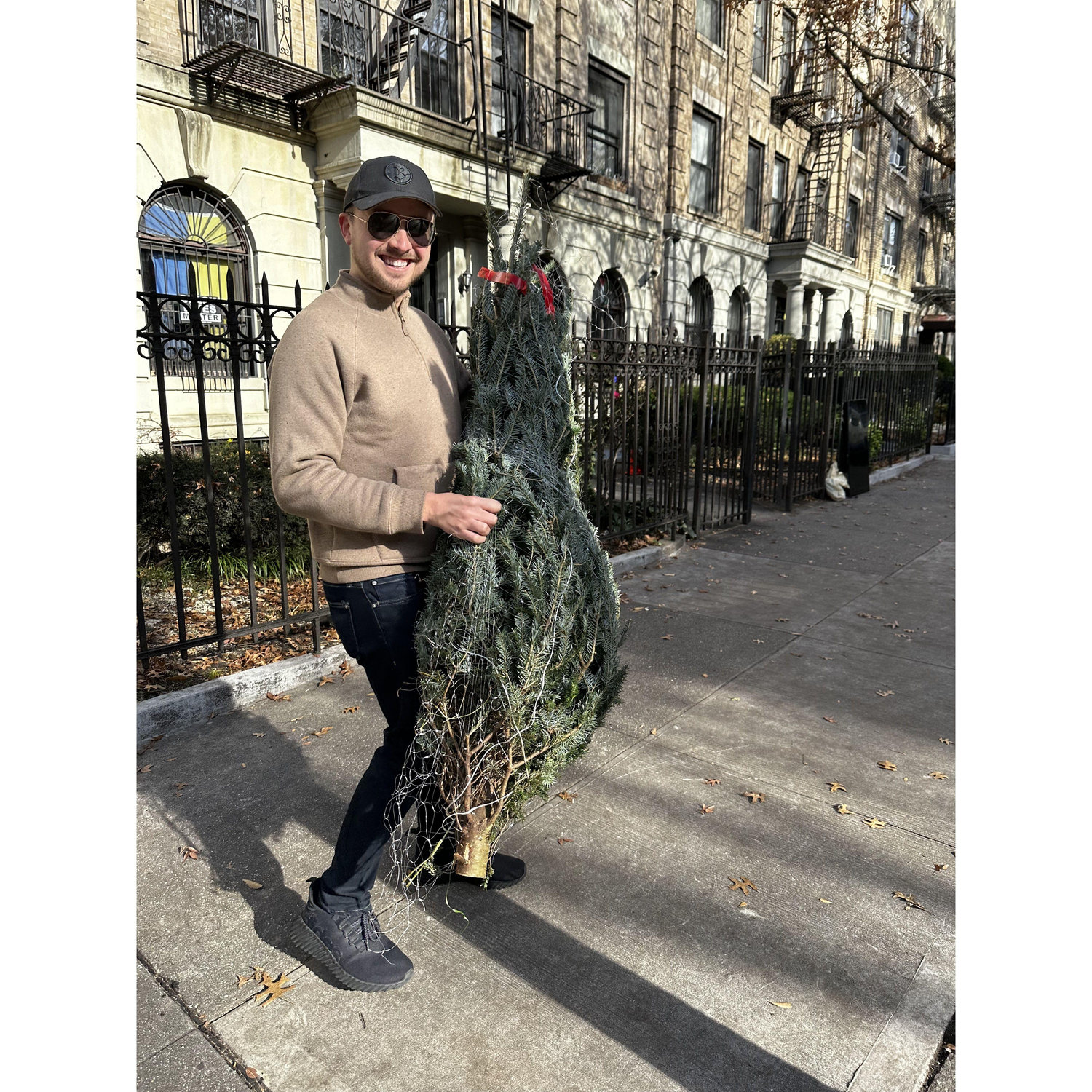 Schlepping our Christmas tree down the block from the seller outside our neighborhood bodega
