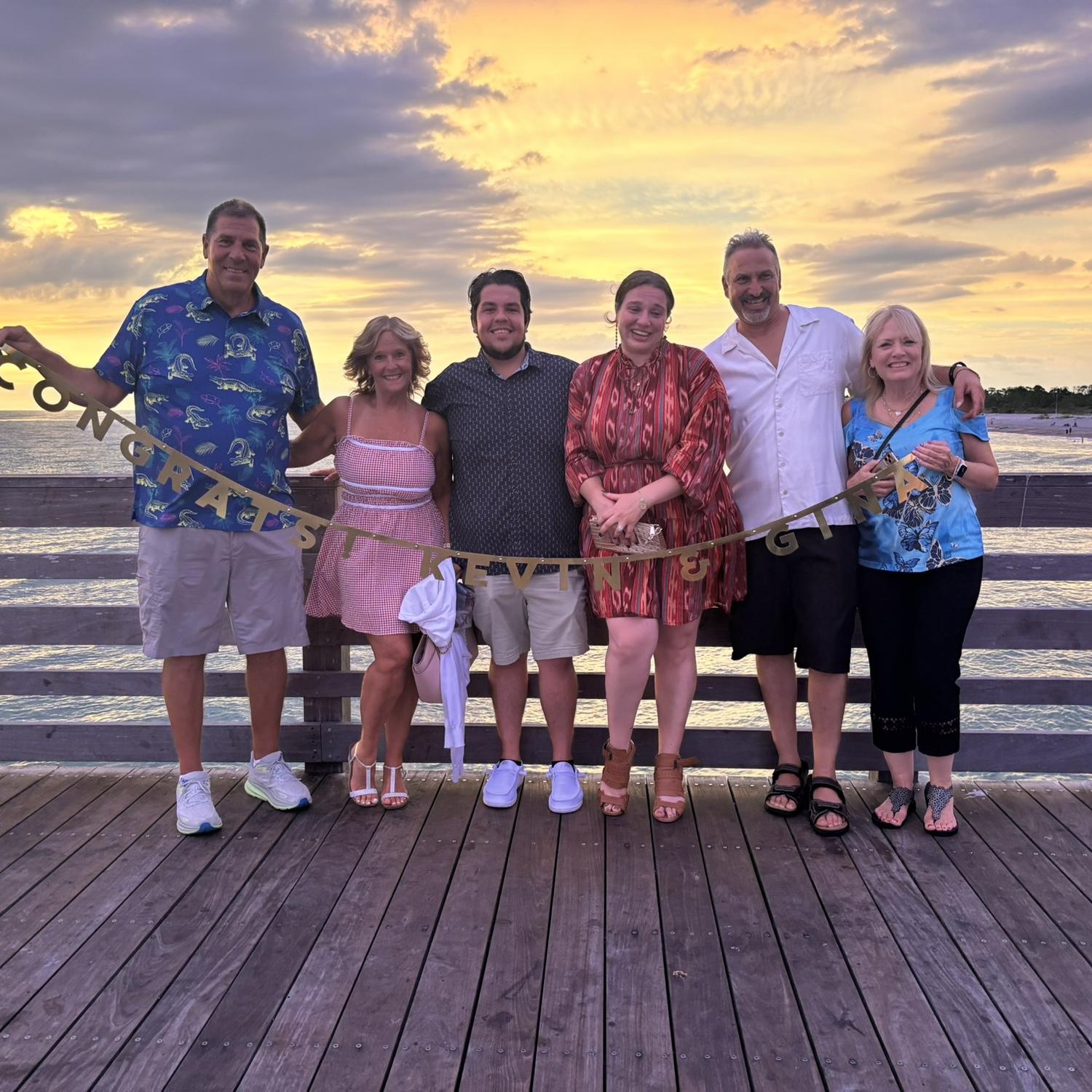 As they continued walking down the pier after the proposal, she saw both families at the end of the pier waiting for her to see them and them to see her. Immediately, tears started running.