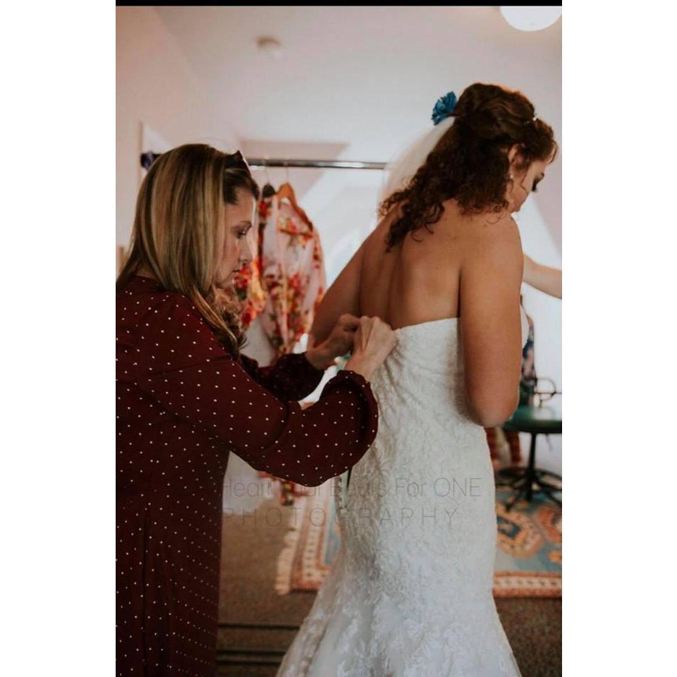Wendy Freyman helping the bride with getting the dress on
Photo credit to: A Heart That Beats For One Photography