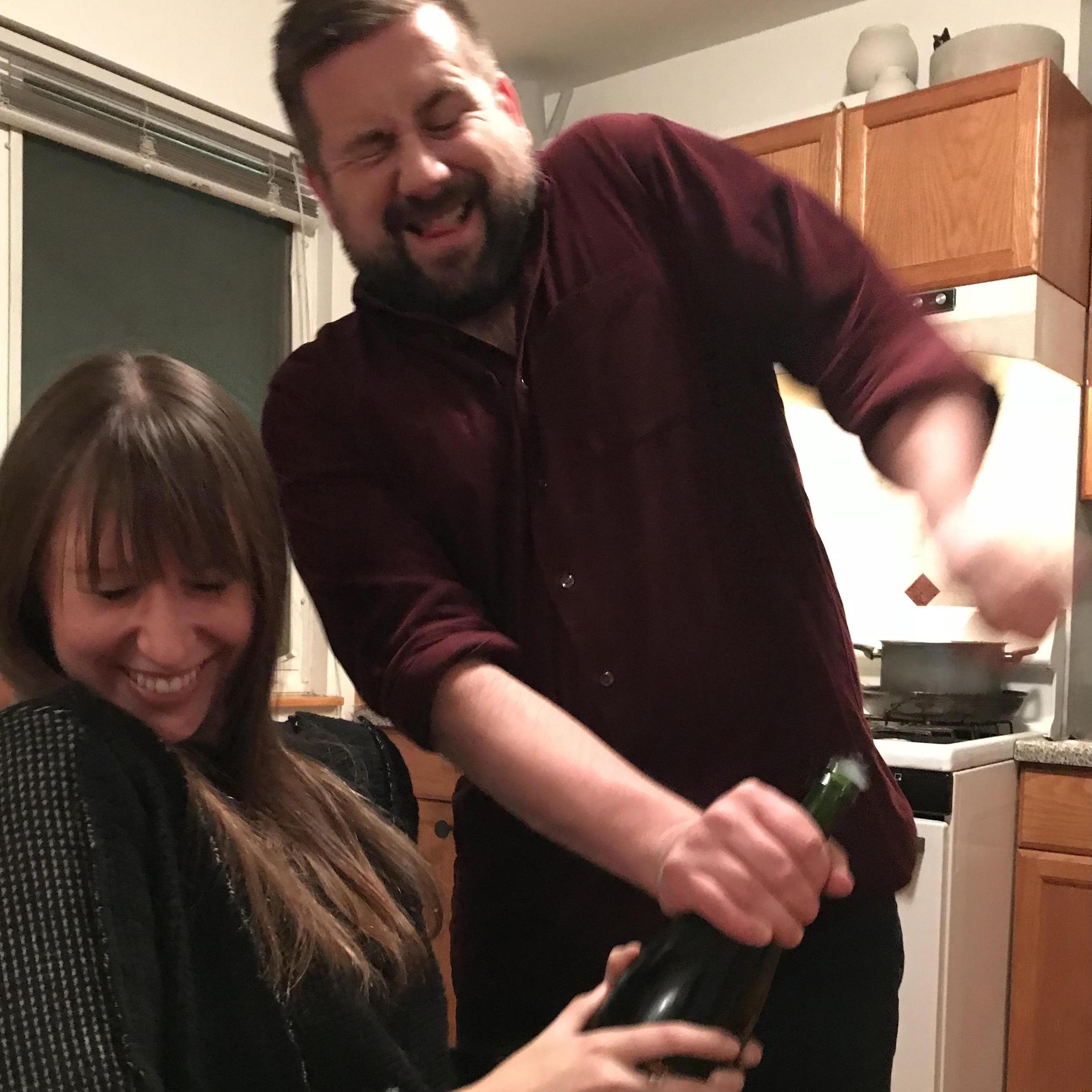 Team effort in popping engagement champagne bottles!