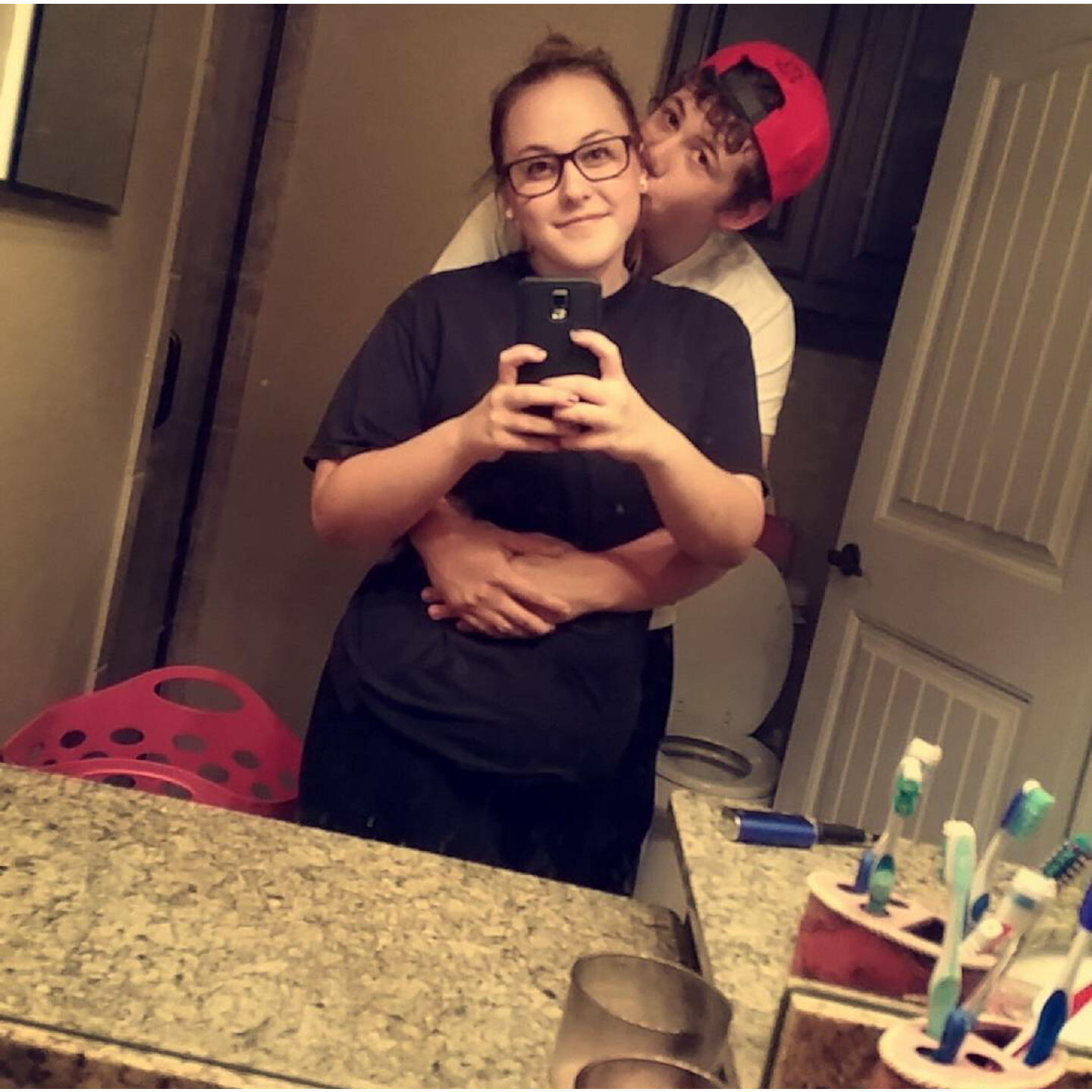 Taking a selfie in the bathroom mirror looking cute in glasses.