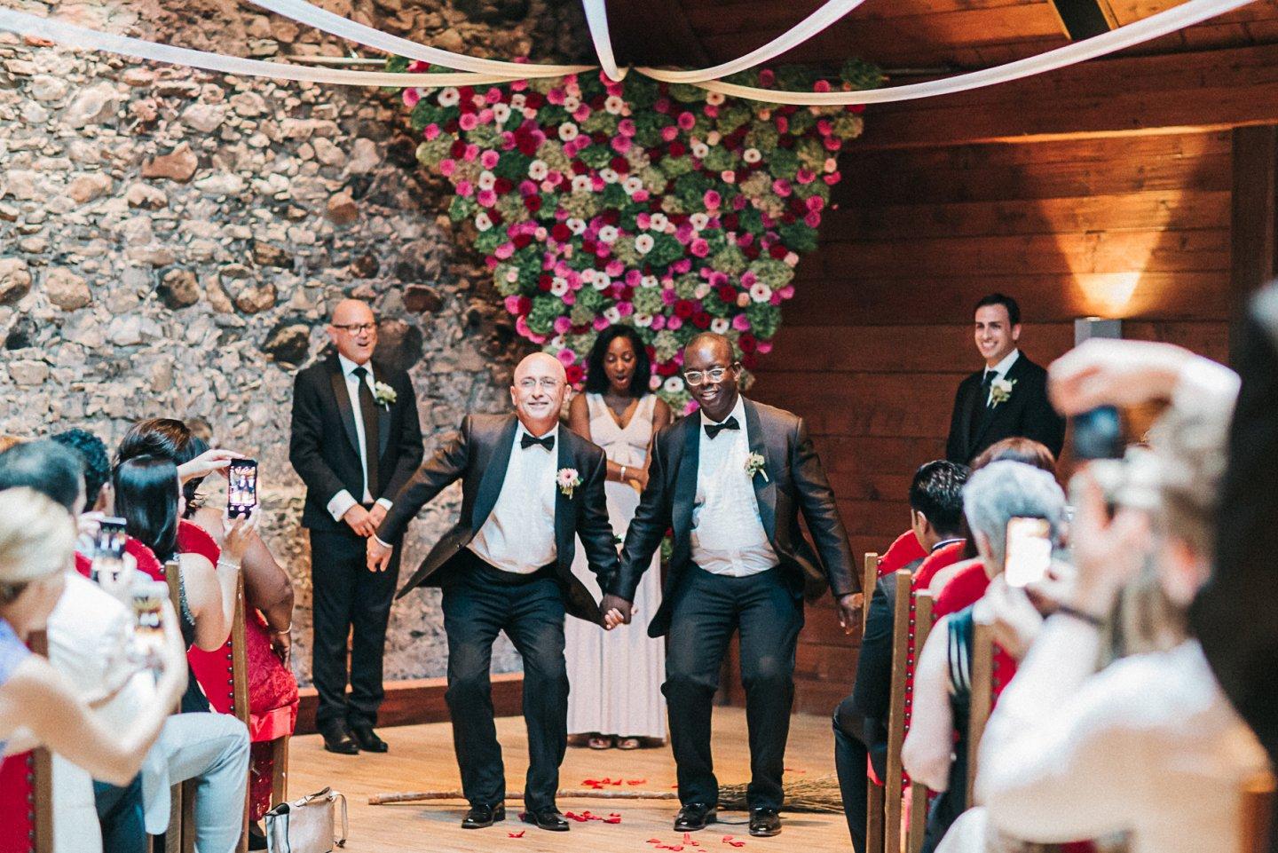 Jumping the broom! A black tradition passed along from when it was illegal for slaves to marry. Flower triangle a nod to gays persecuted in the Holacaust.