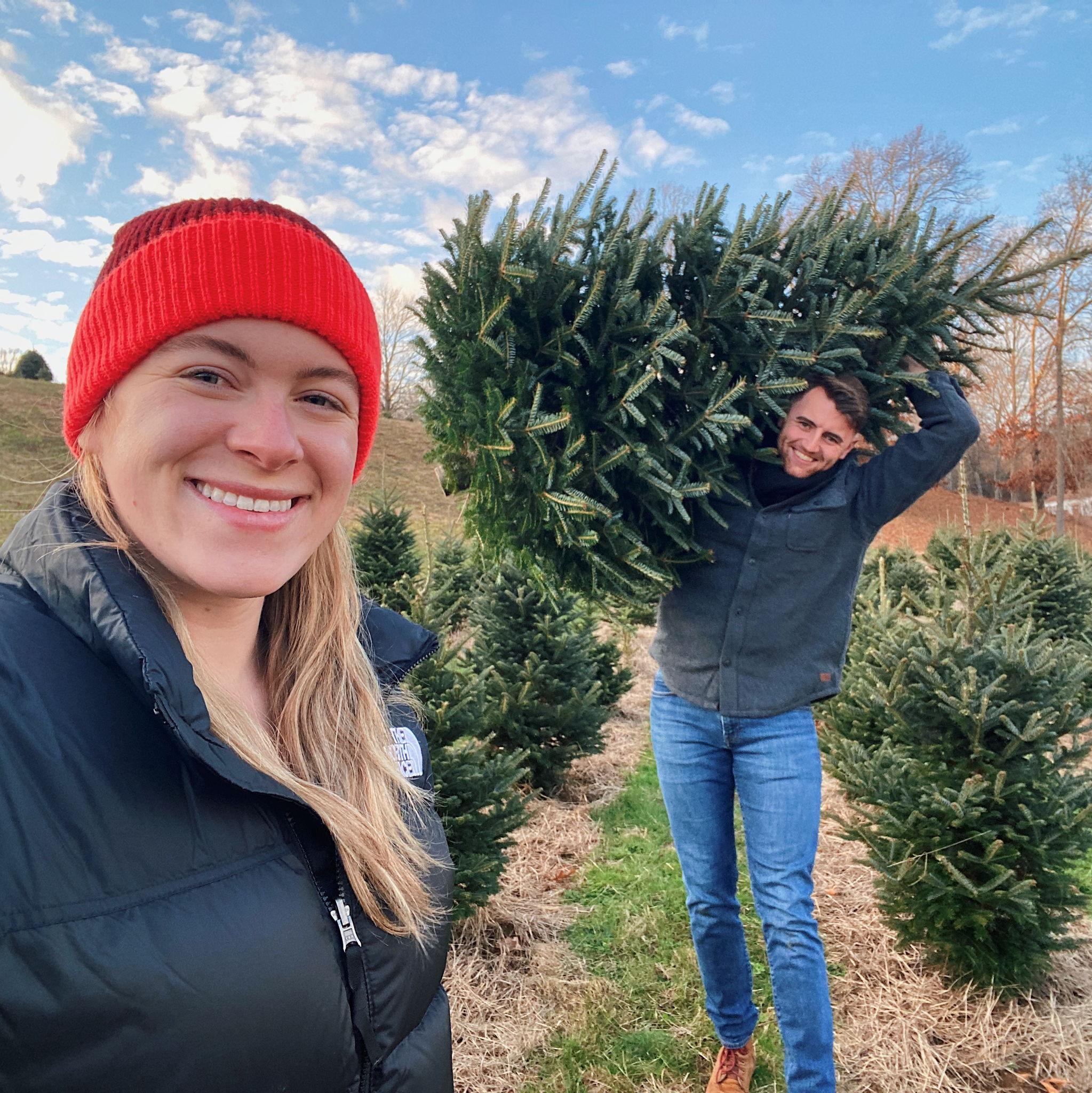Taylor cutting down our Christmas tree, with Elizabeth providing moral support