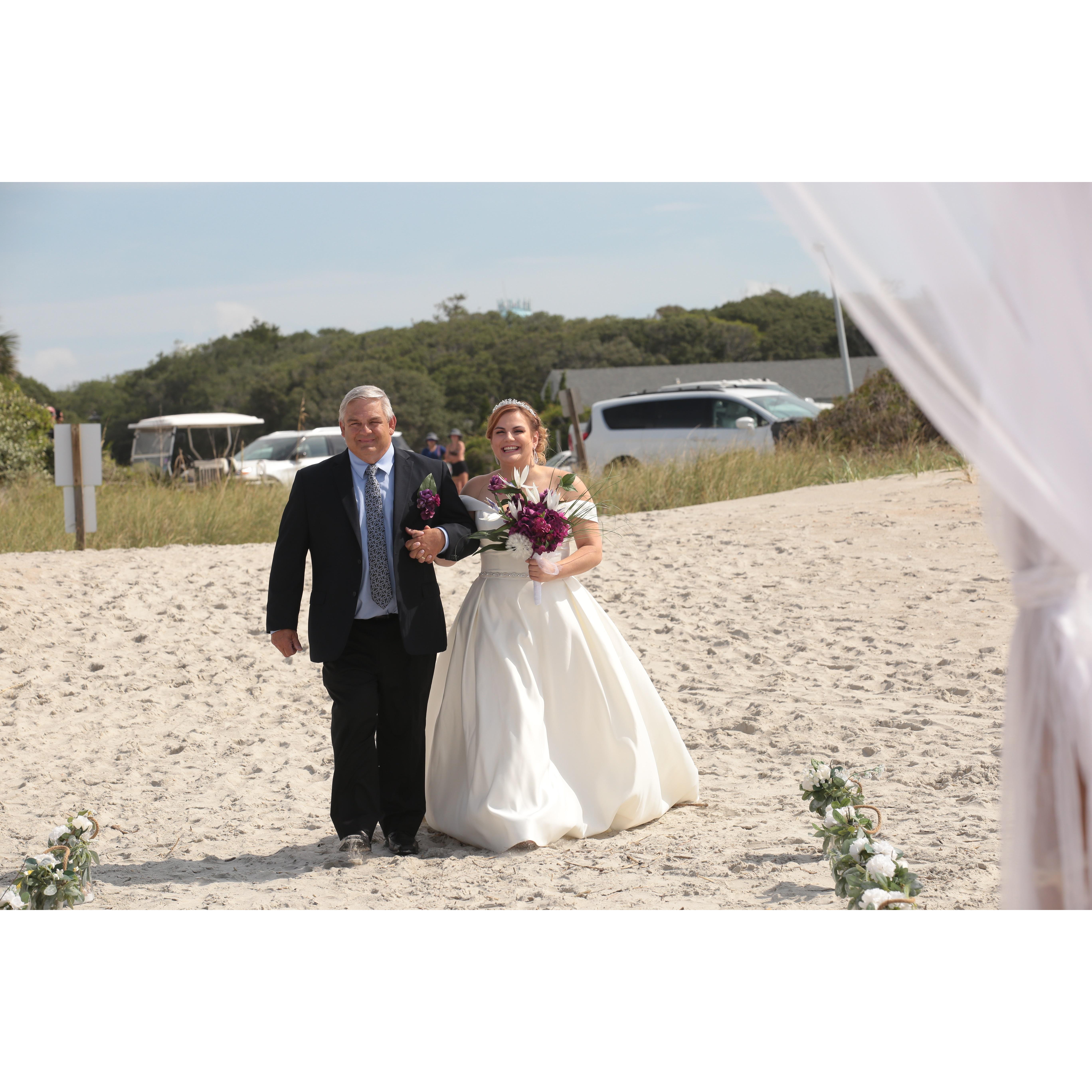 The bride being walked down the isle by her father