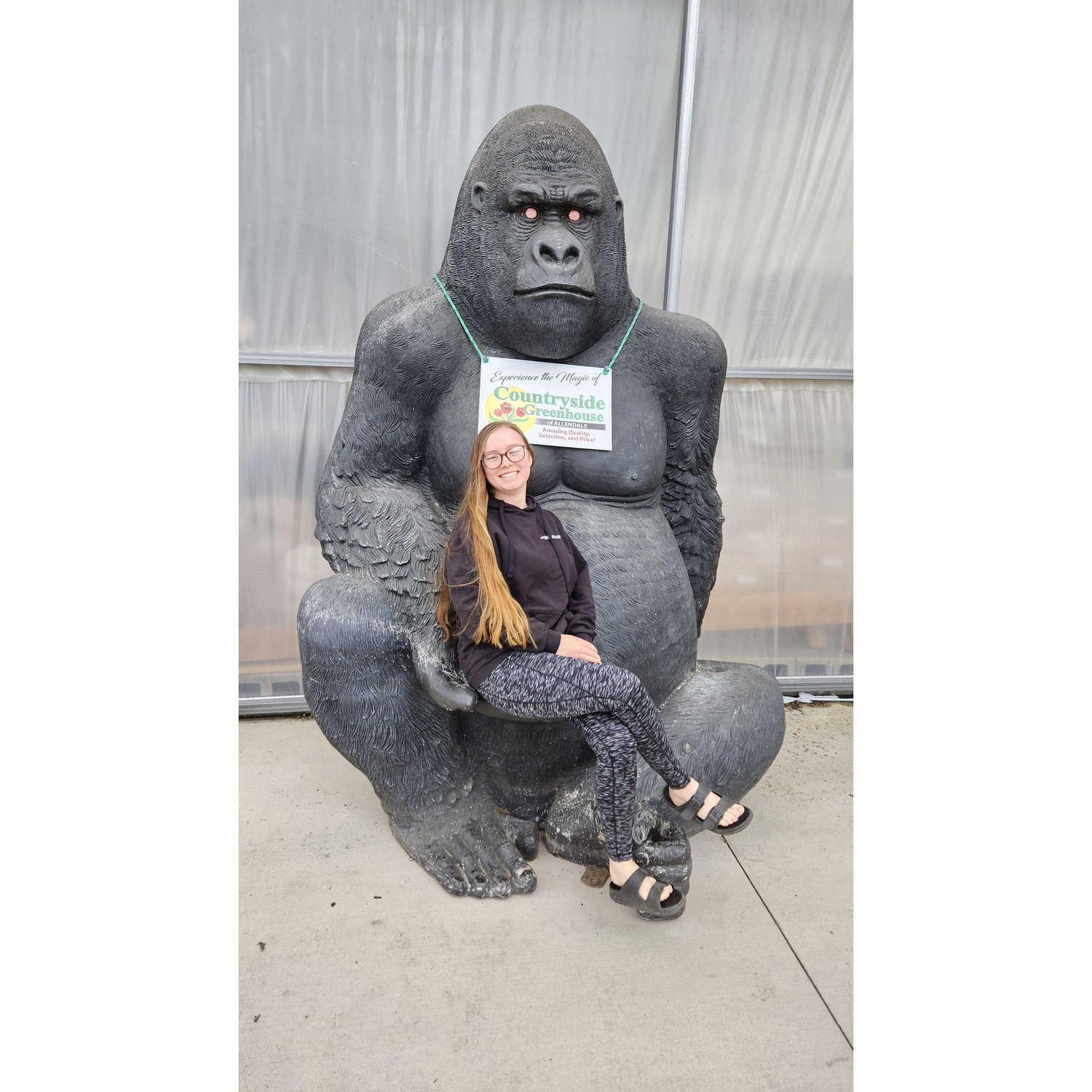 Ally sitting on one of the animal statues in Country Greenhouse in Allendale