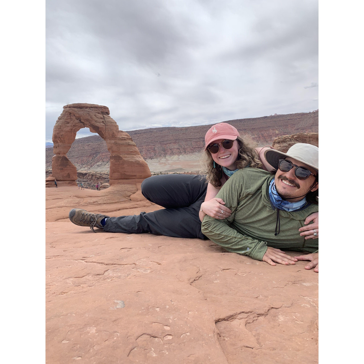 Adam and Hannah posing in front of Delicate Arch in Arches National Park.