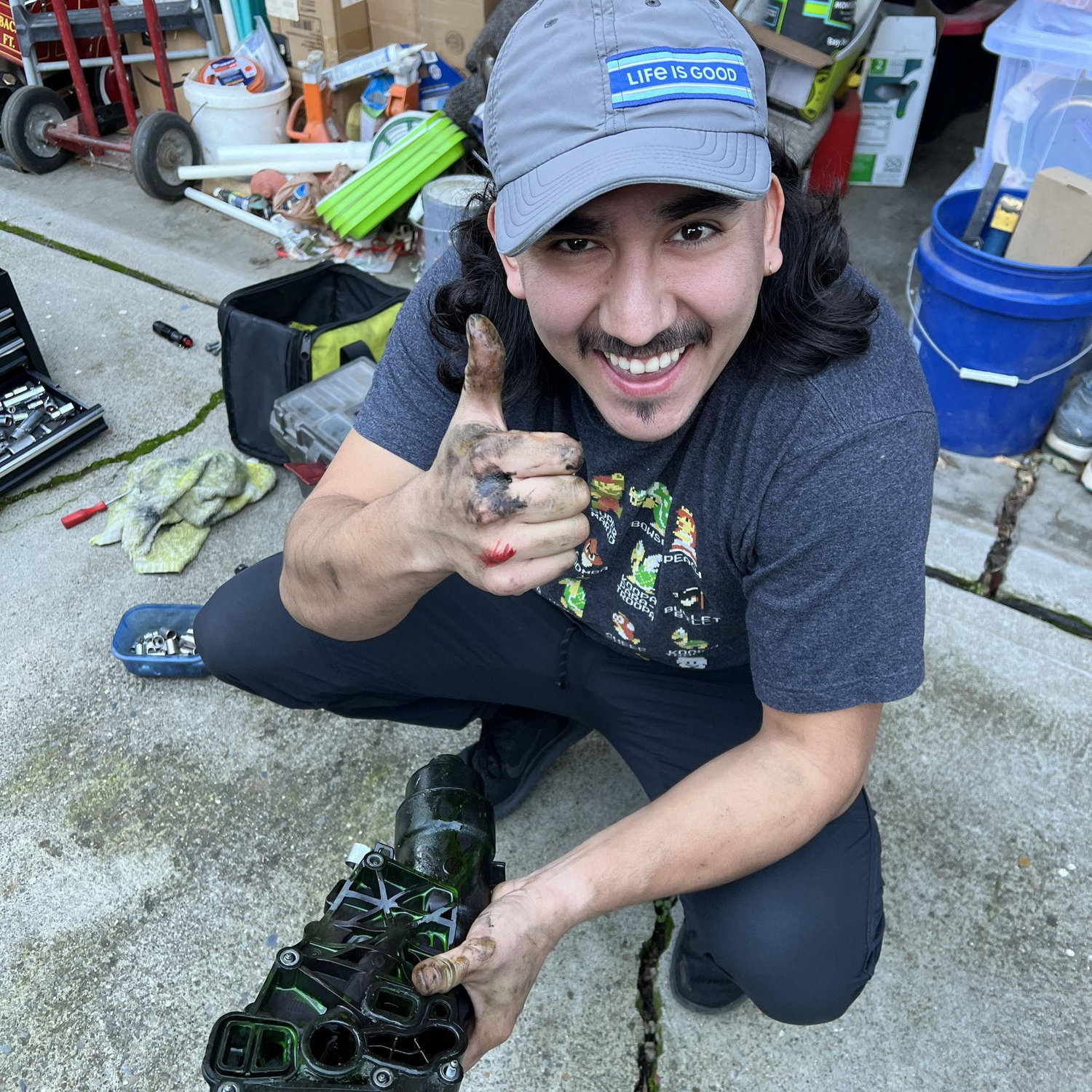With blood, sweat, and grime, Jesus surgically extracts the broken oil filter housing of Jenna's problematic car.