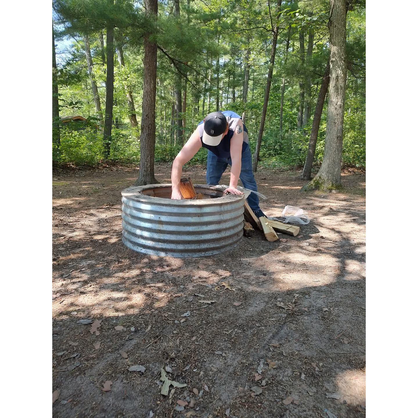 Brad builds a better fire than Hillary. This is at Interlochen State Park in 2024.