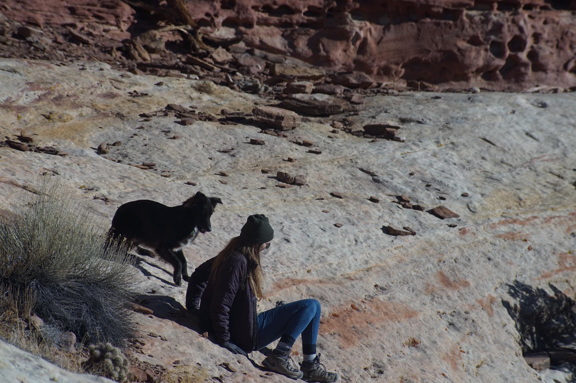 Chiso helping Shaylee scramble down from a pictograph site along the Escalante River in Utah