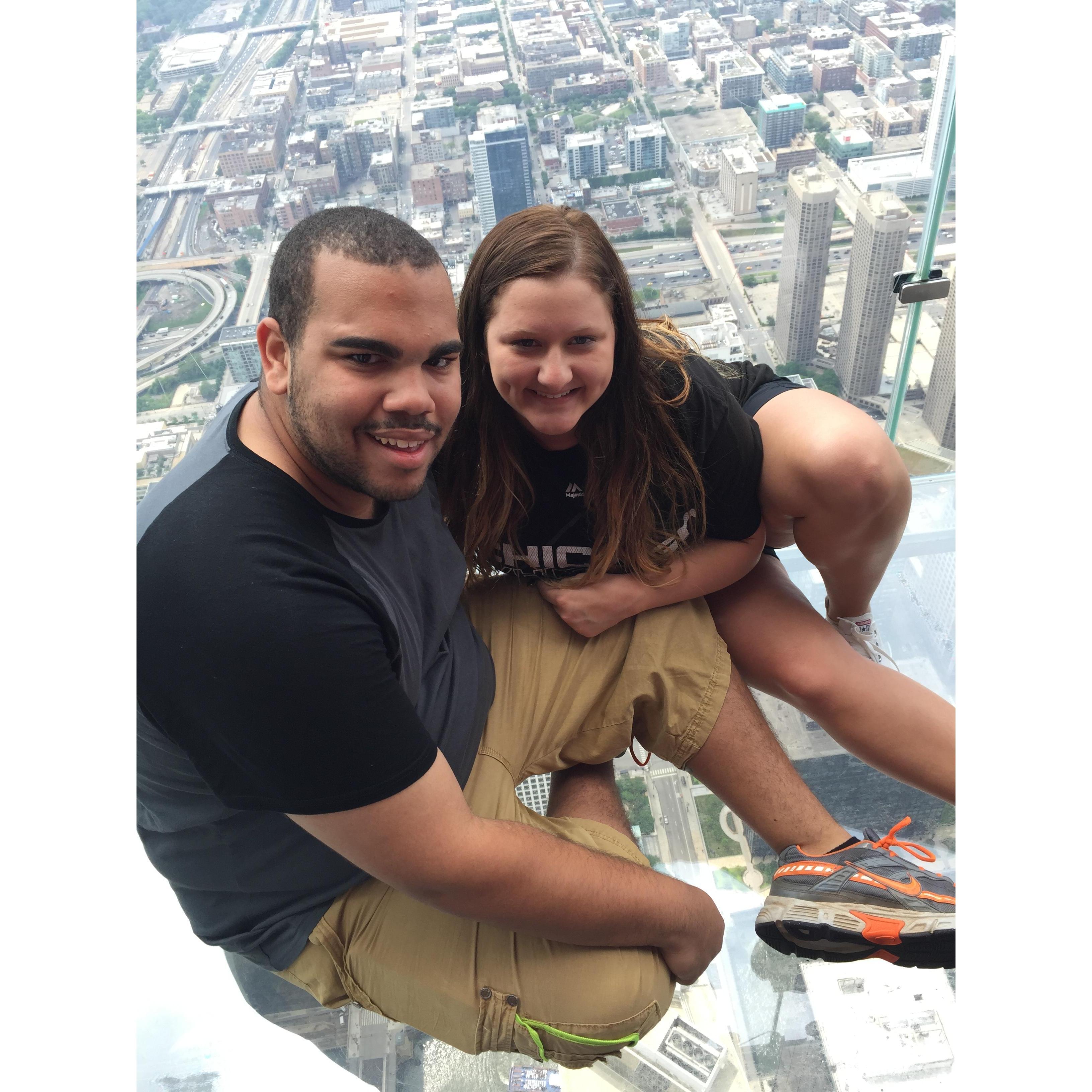 Sitting over the city of Chicago on the little transparent box that hangs over the side of the building!