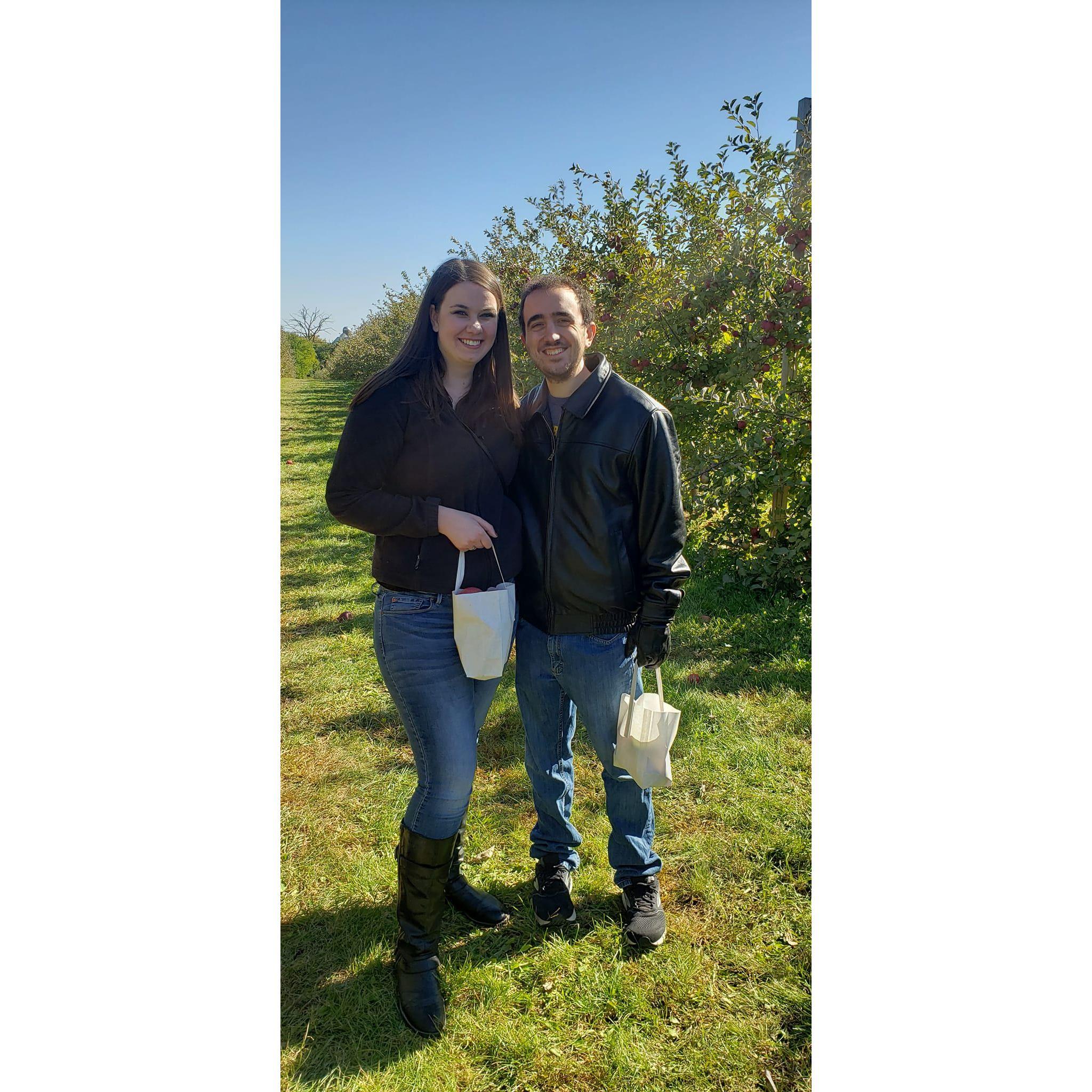 Cuddling to stay warm while apple picking.