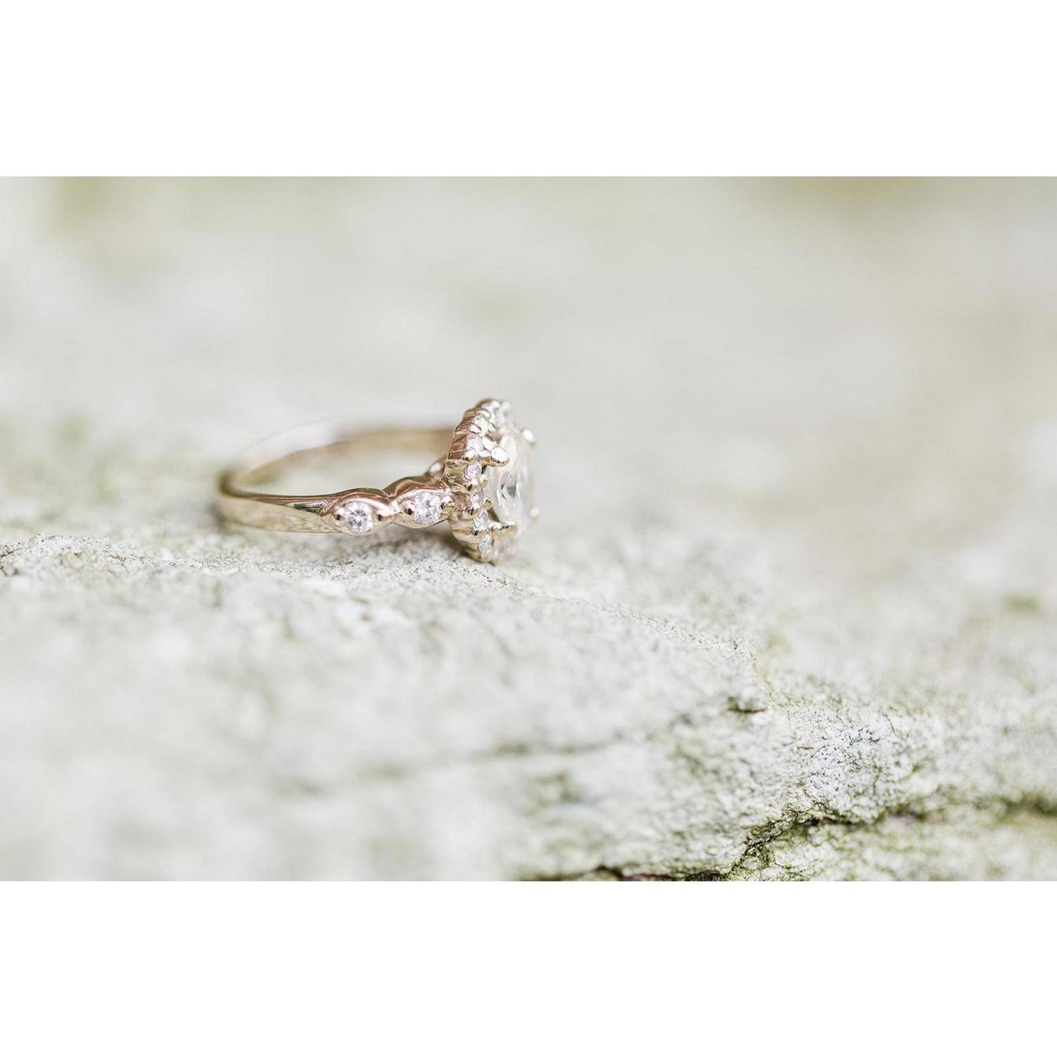 Jay proposed with a gorgeous oval cut diamond in a halo setting with a very special detail; the side stones from his grandmother's engagement ring.
