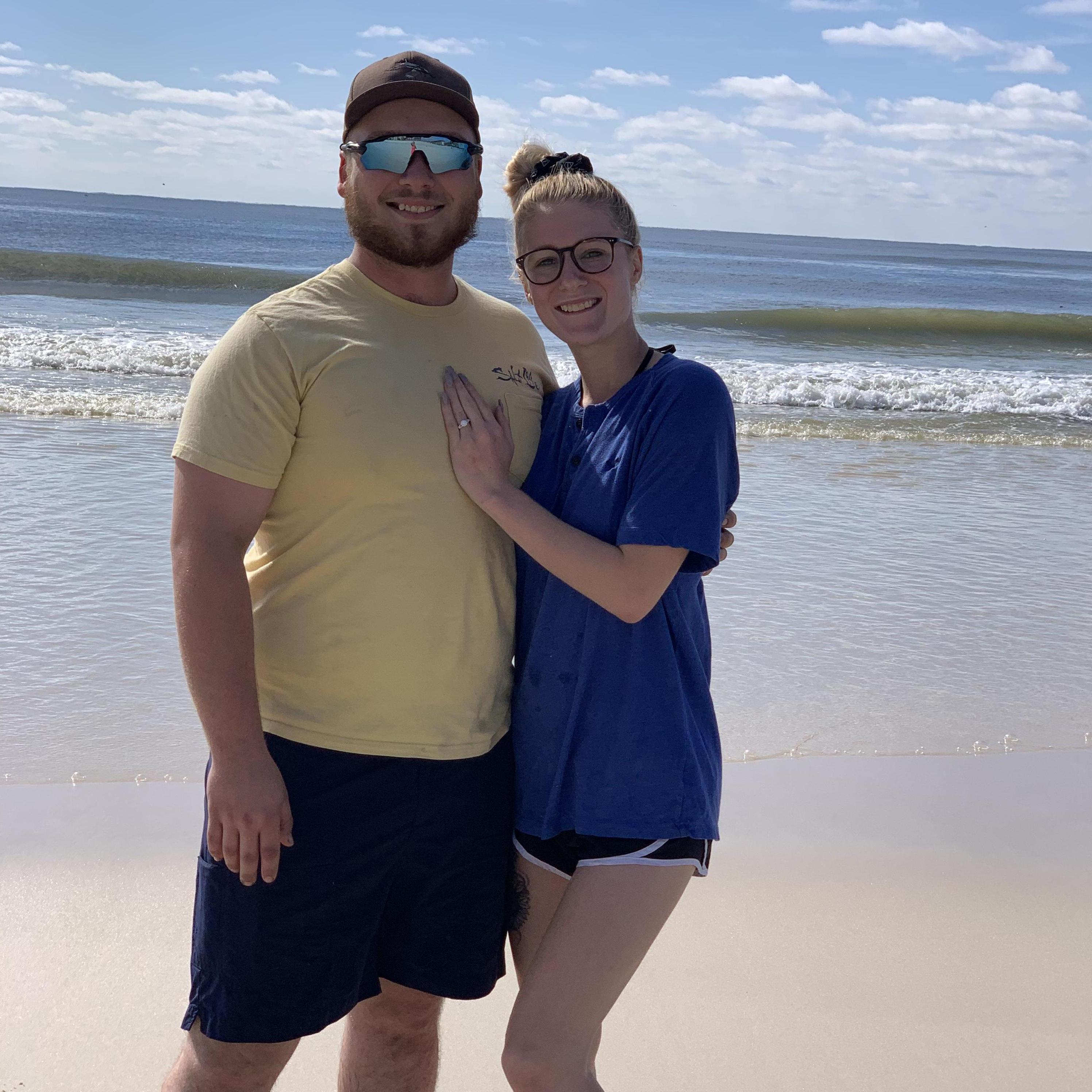 The morning after we got engaged! Walking down the beach and a lady offered to take our picture.