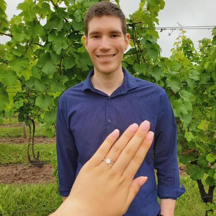 Lia's beautiful engagement ring with Jon smiling behind