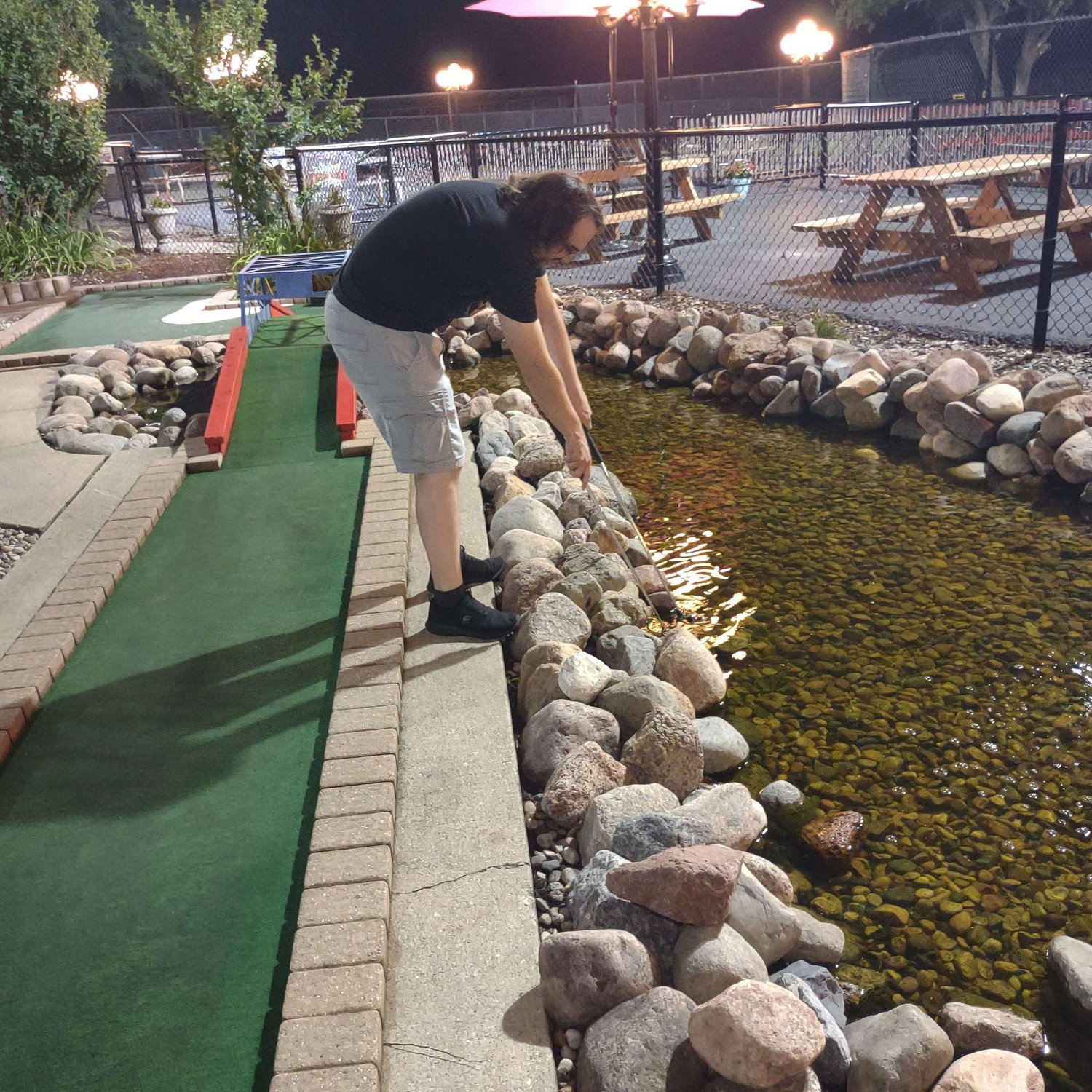 Alex pretends to be grumpy while fishing out Arliss' golf ball. The two still love to play, even if his wife still loses her ball...repeatedly.