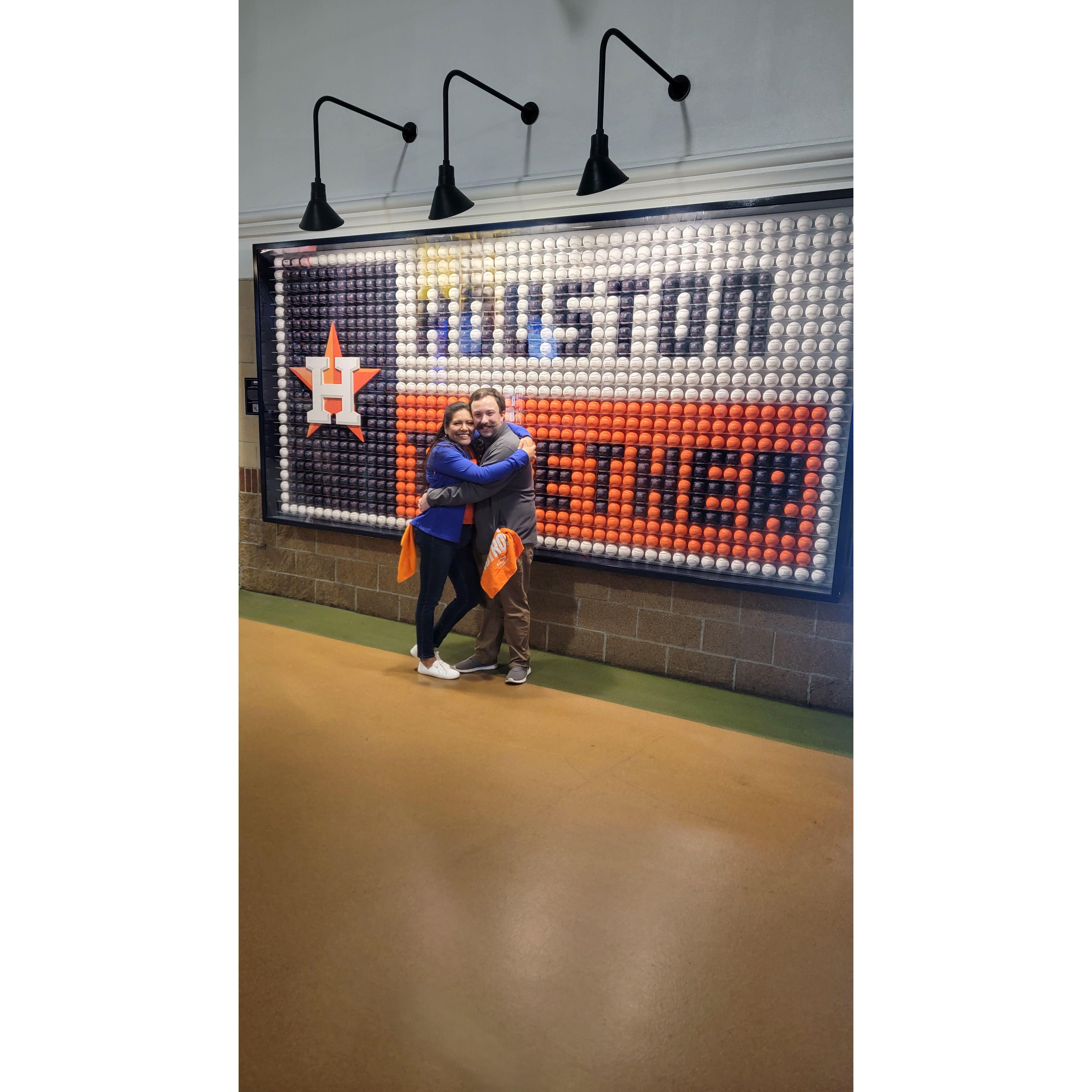 Laura and Joseph, united in love and team spirit, get a photo in front of an Houston Astros art installation, hitting a home run into their new life together