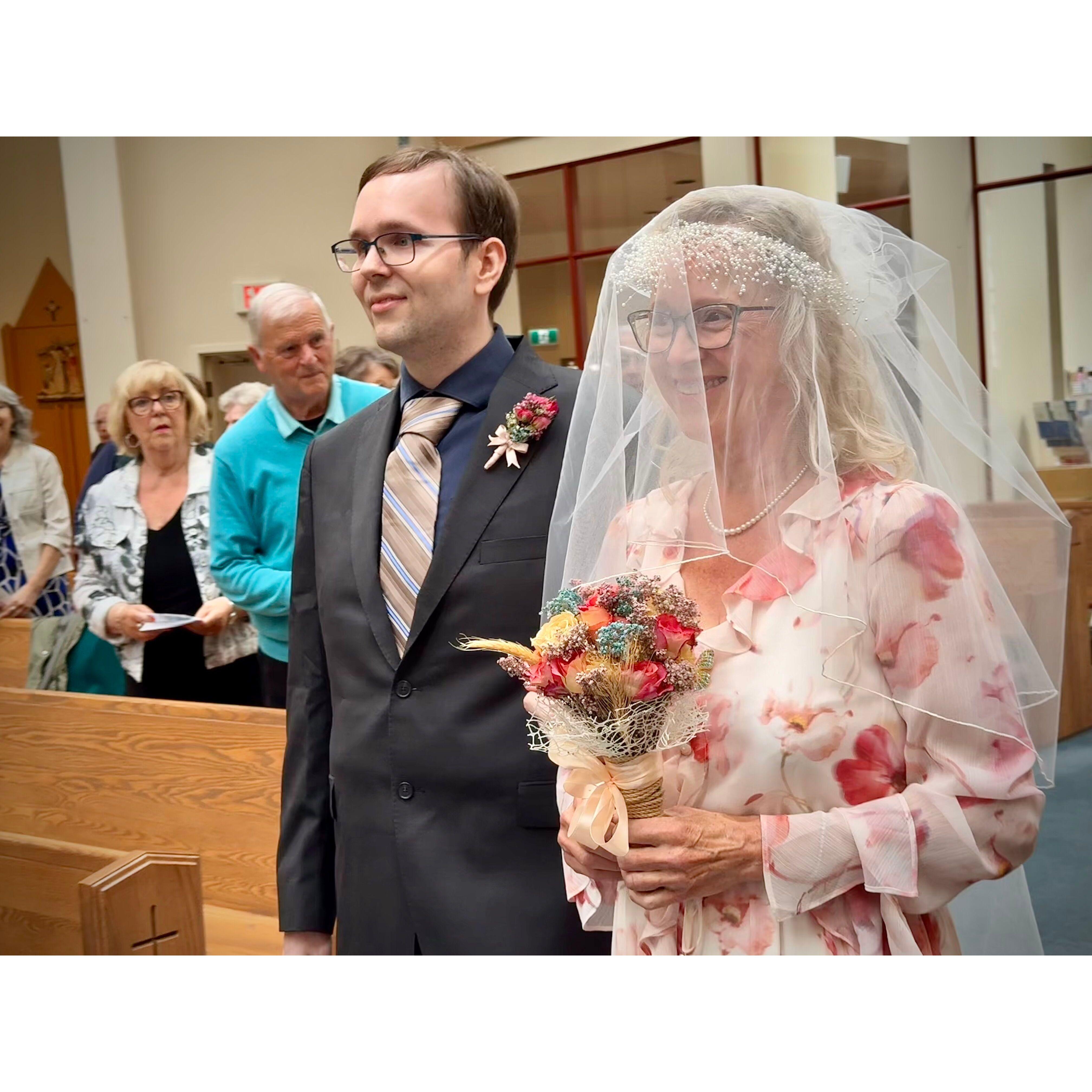 Ryan leads his Mom to the front of the church.