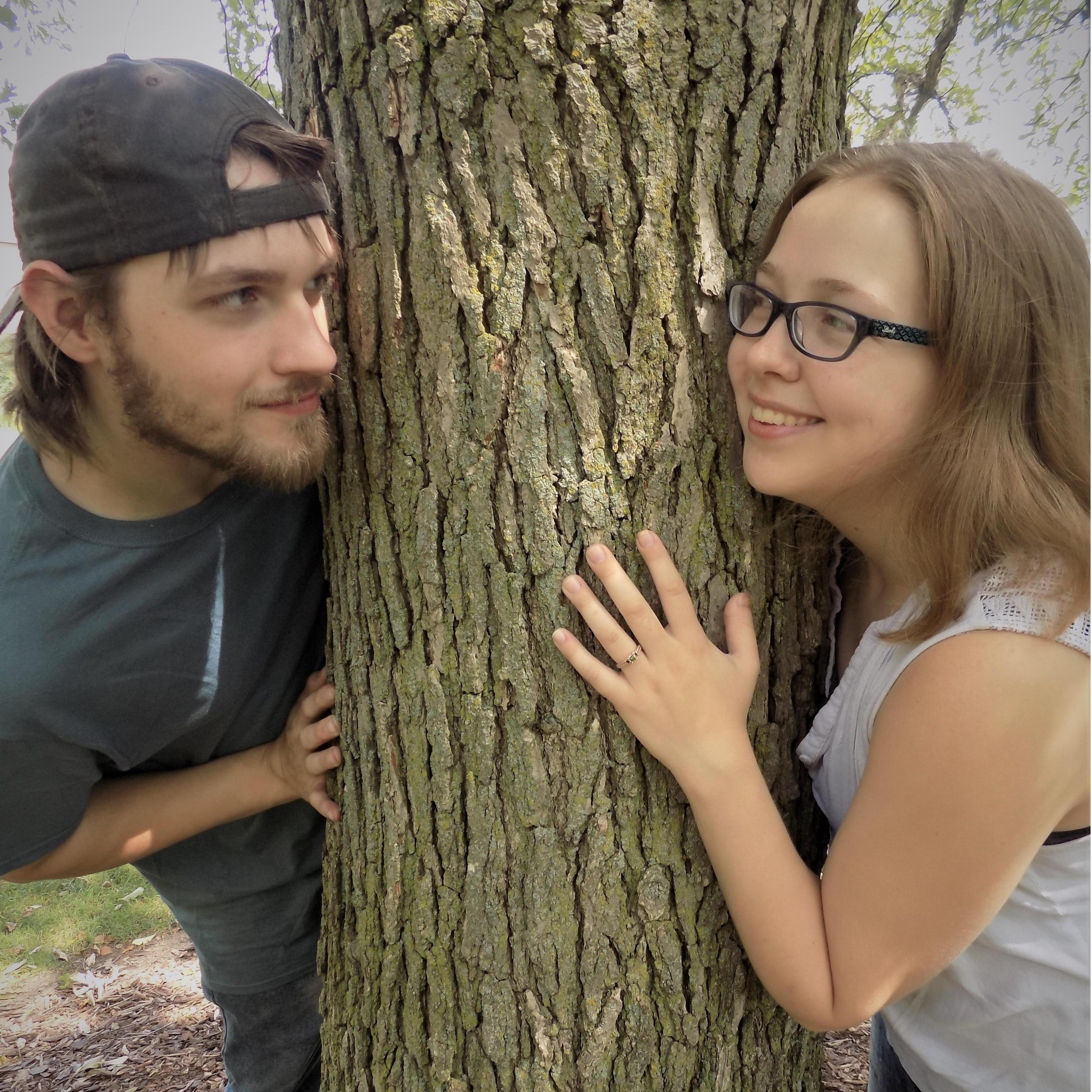 Peering around the tree at each other.