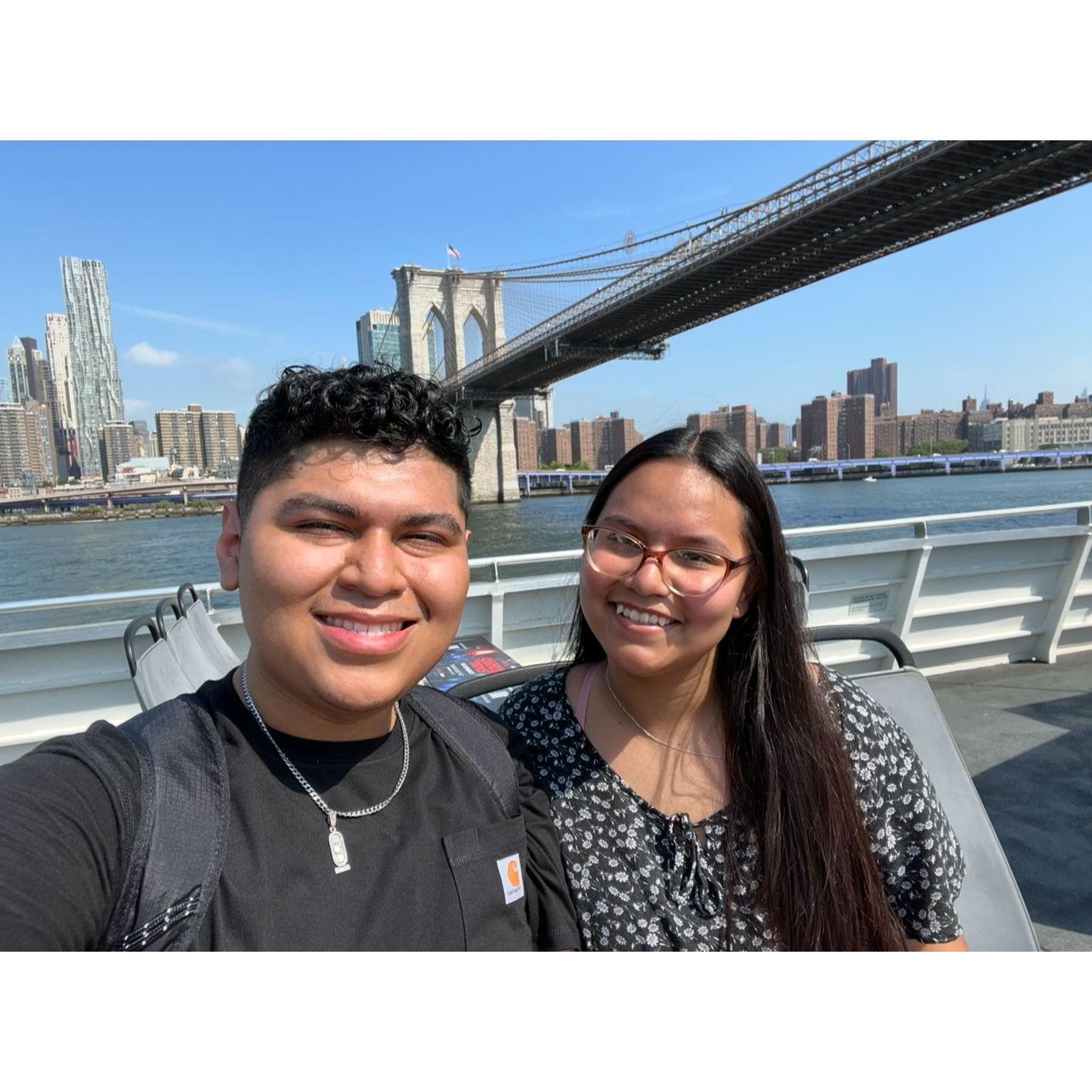 A New York ferry ride passing under the Brooklyn Bridge. Un paseo en ferry por Nueva York pasando bajo el puente de Brooklyn.