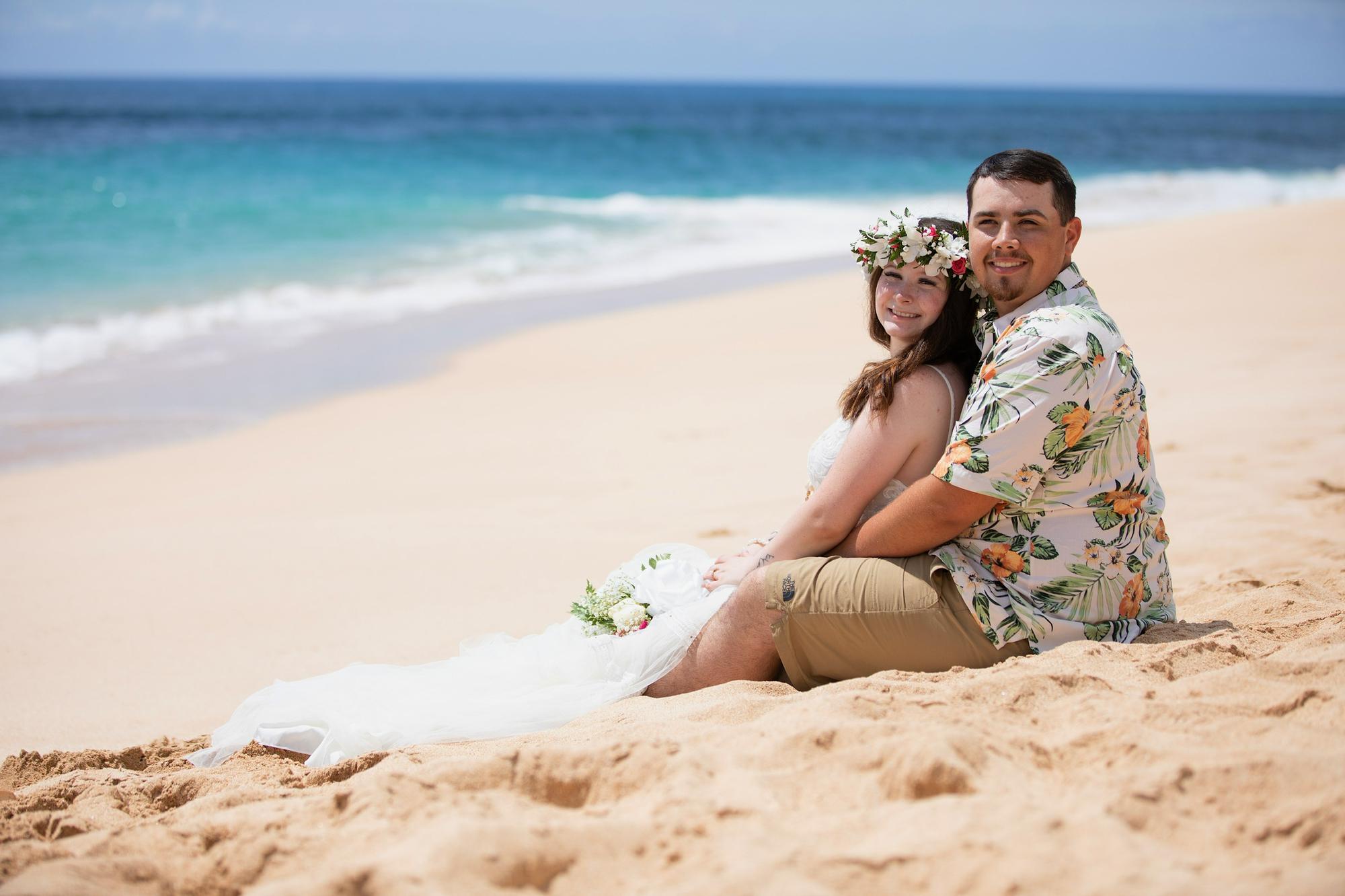 Relaxing after their wedding ceremony in the sand 2021