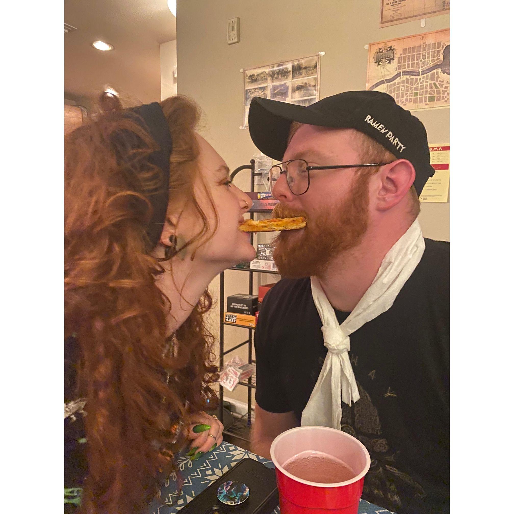 Sharing a pizza crust at a game night with friends.