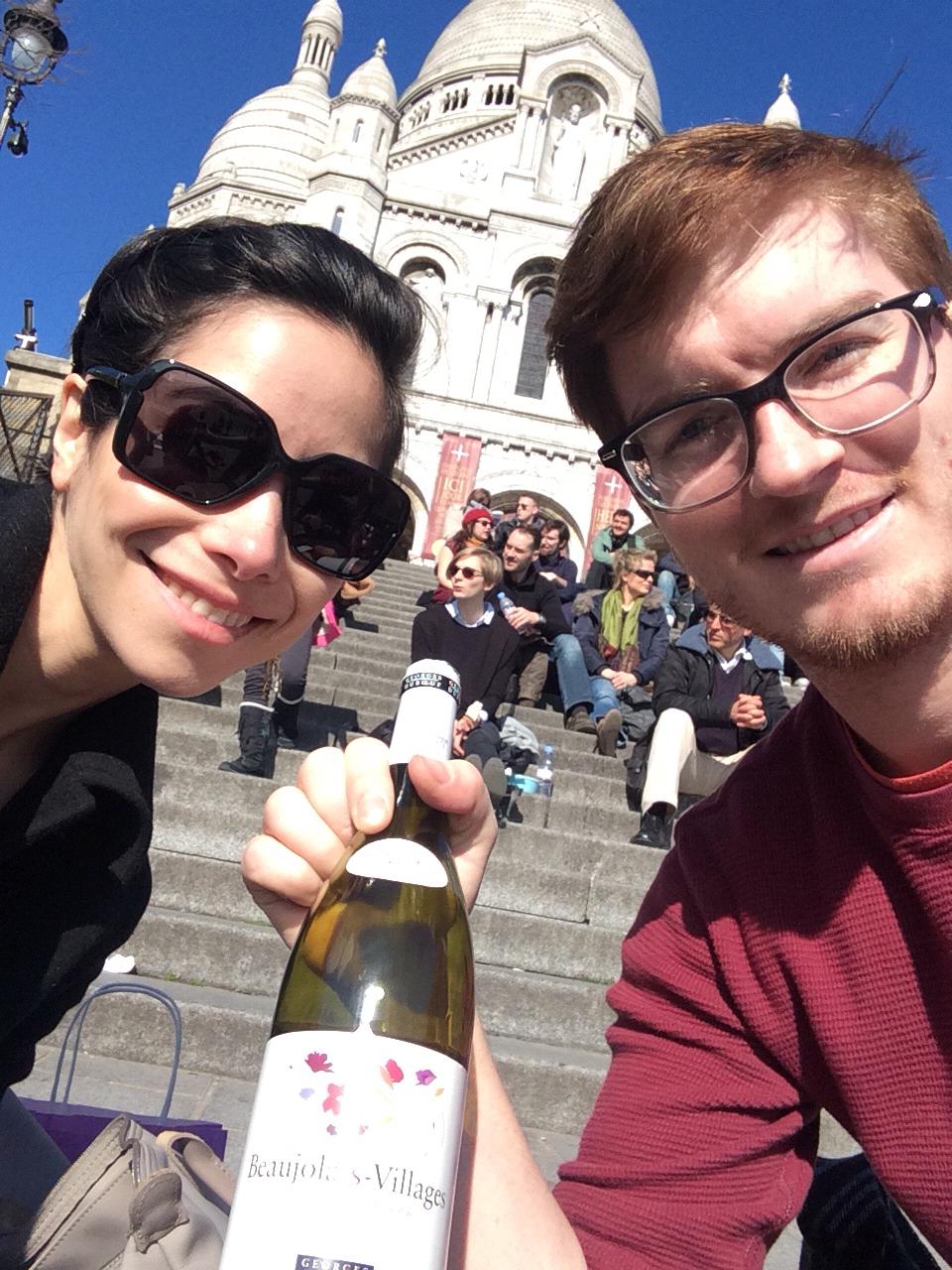 Drinking a bottle of wine Melody's parents bought them at the top of the steps of the Basilica Sacre Coeur. Melody's parents drank the same bottle of wine at the same place during their honeymoon.