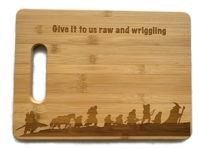 "Give it to us raw and wriggling" Lord of the Rings Fellowship Walking Up A Mountain Silhouette Engraved Wood Cutting Board Sustainable Bamboo with Handle 9.5"x13"