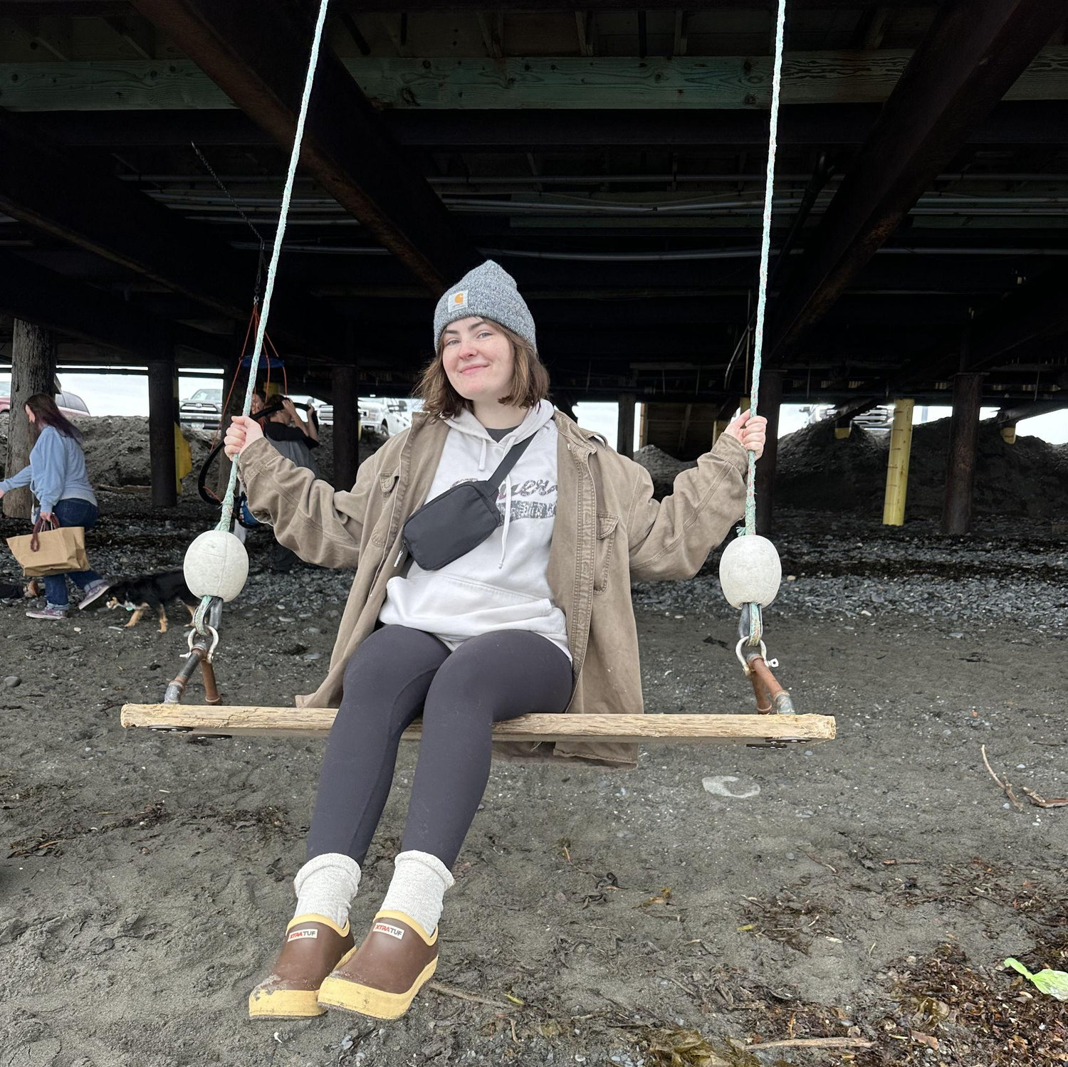Julianne trying not to fall off a swing on the Homer Spit.