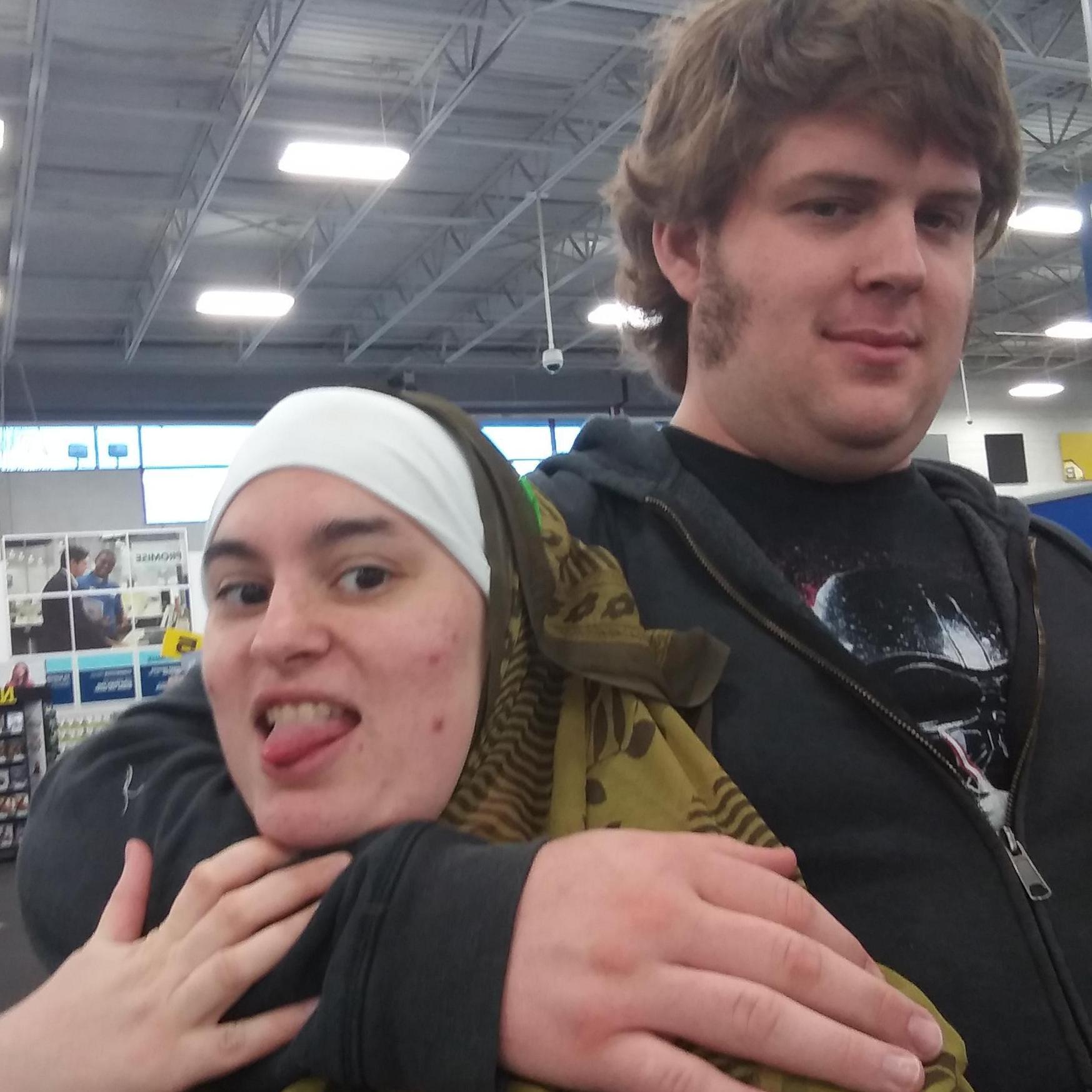 Taking a selfie at Best Buy and he surprise hugs me! I go with it and take the photo. WE FELL into the shelves behind us!